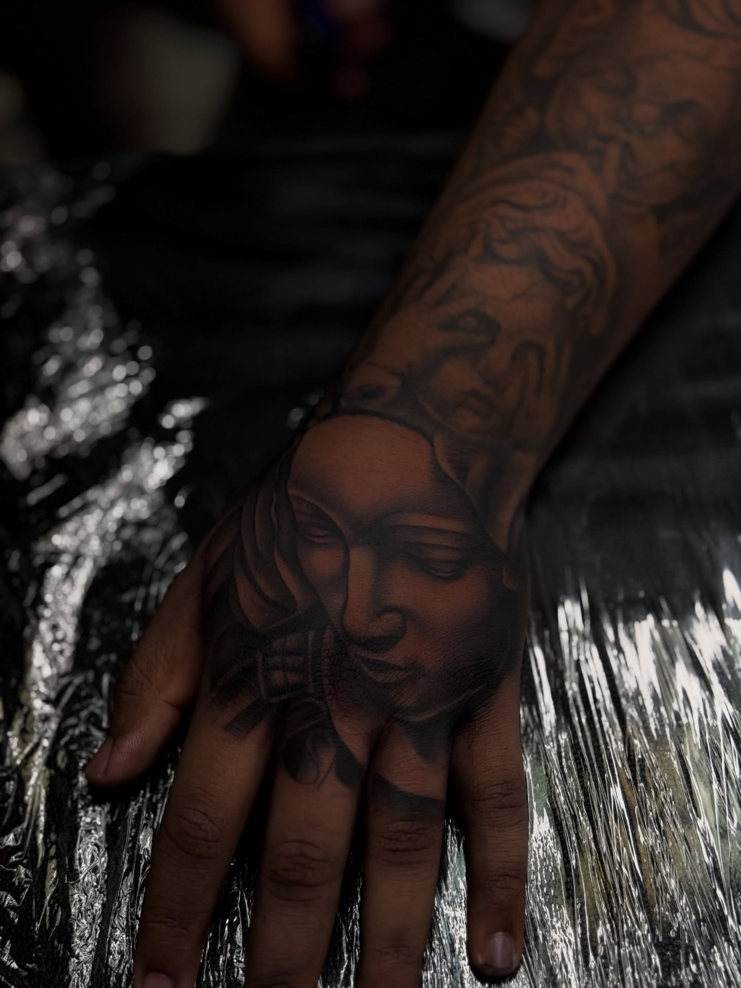 Woman's face realism tattoo on the hand by Savannah Tattoo Artist