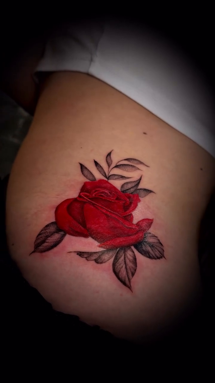 Red rose with leaves neo-traditional tattoo on the thigh by Nyc Tattoo Manhattan