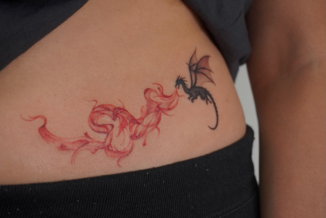 Dragon and flame watercolor tattoo on the ribs by Sun Child Tattoo 🌻