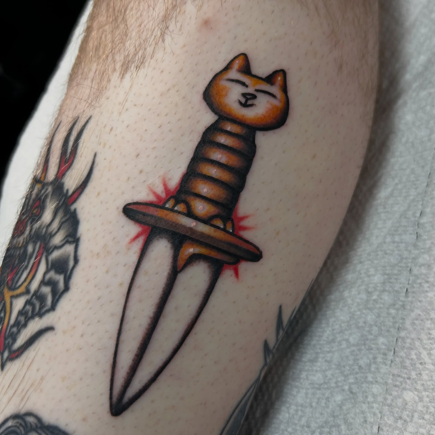 Cat knife American traditional tattoo on the forearm by Dylan James