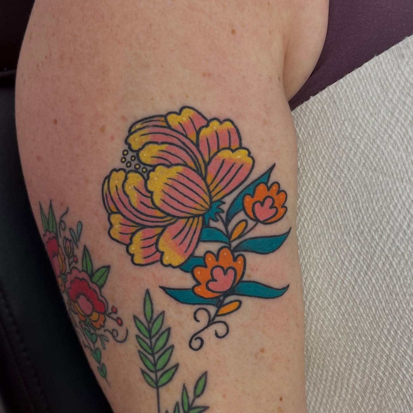 Floral bouquet American traditional tattoo on the upper arm by Alena McDonald