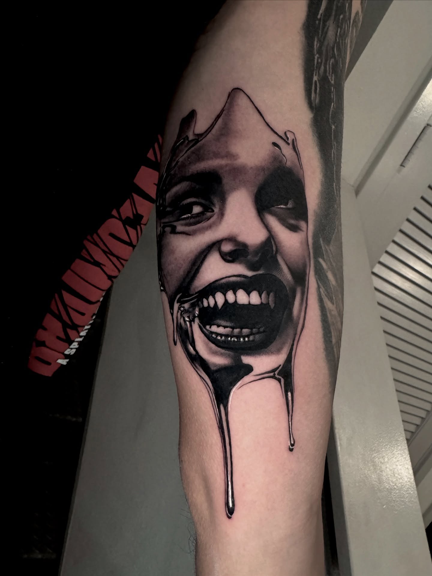 Horror clown dark realism tattoo on the forearm by Gabriel Quintana “Q”