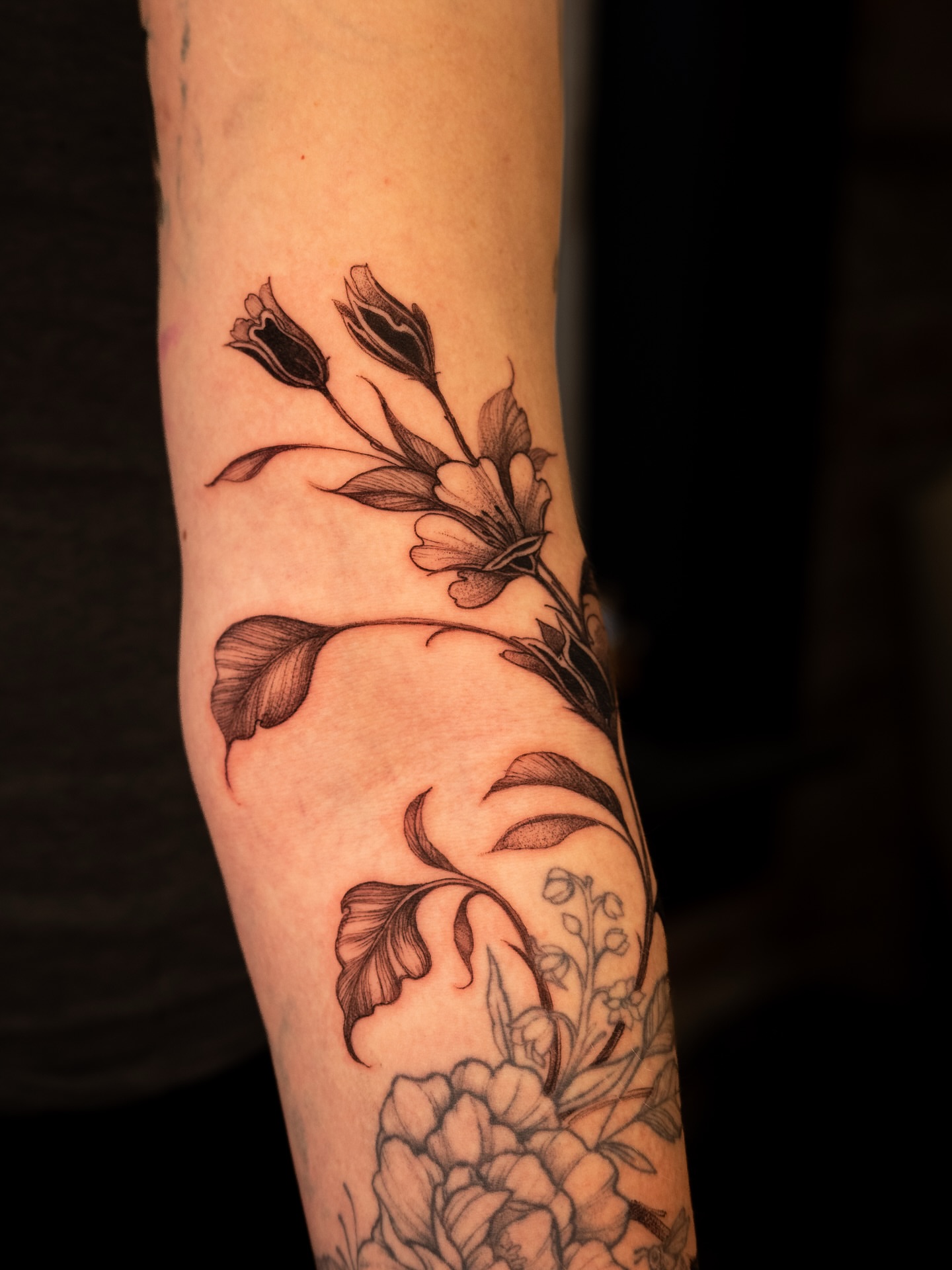 Floral bouquet black and grey tattoo on the forearm by Brad Simmons