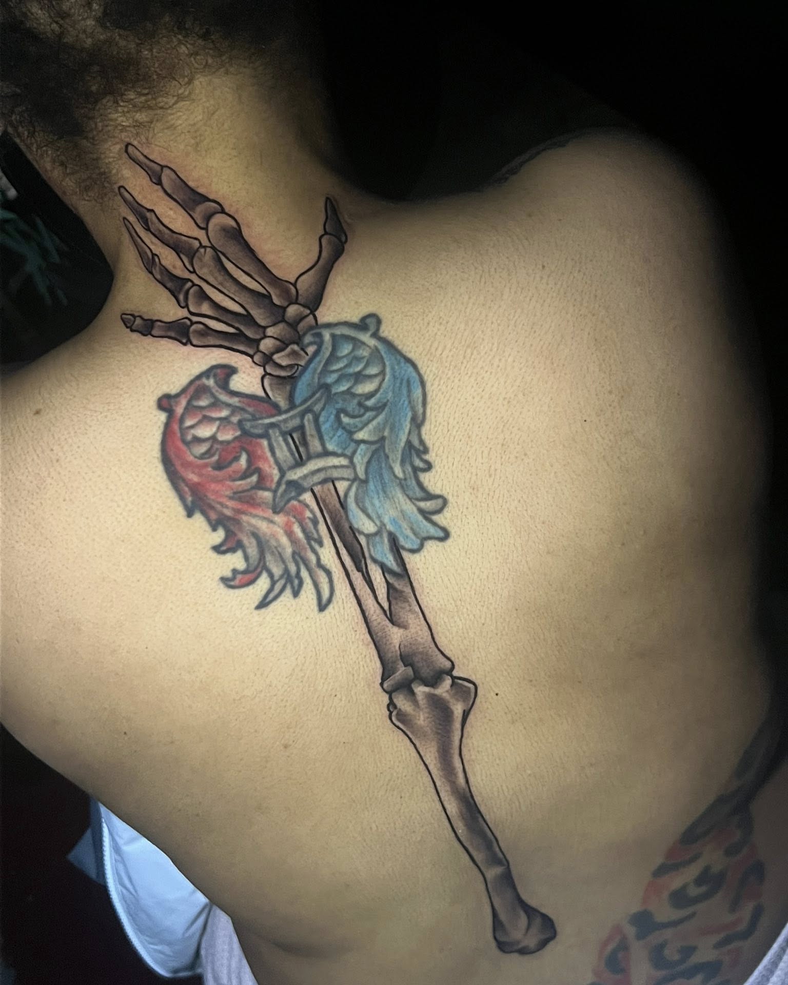 Skeleton hand holding phoenix neo-traditional tattoo on the back by Ferlandis Fitch, Long Beach, California