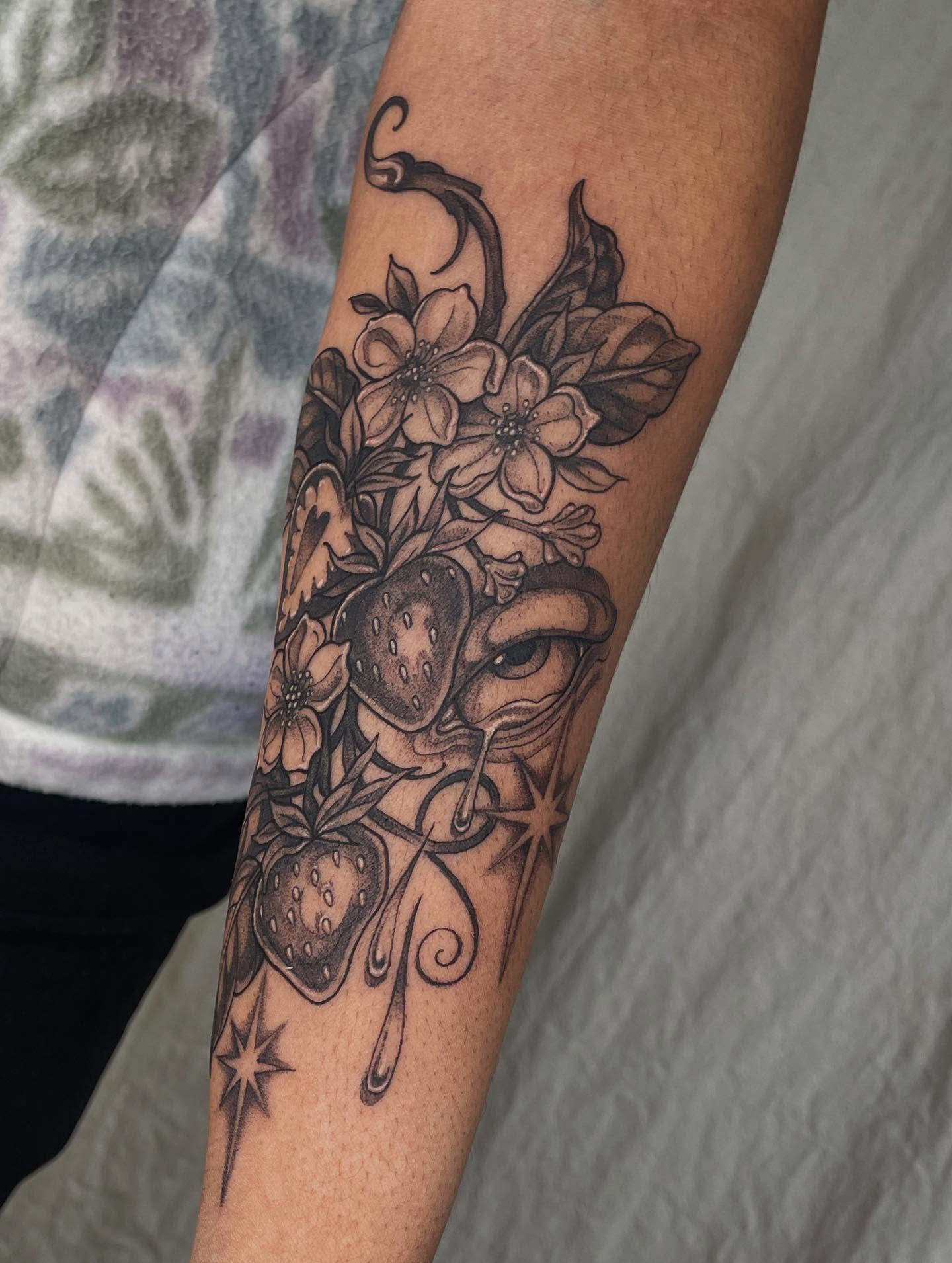 Strawberry and flowers black and grey tattoo on the forearm by 𝖂𝖍𝖆𝖙𝕽𝖊𝖎𝖑𝖊𝖞