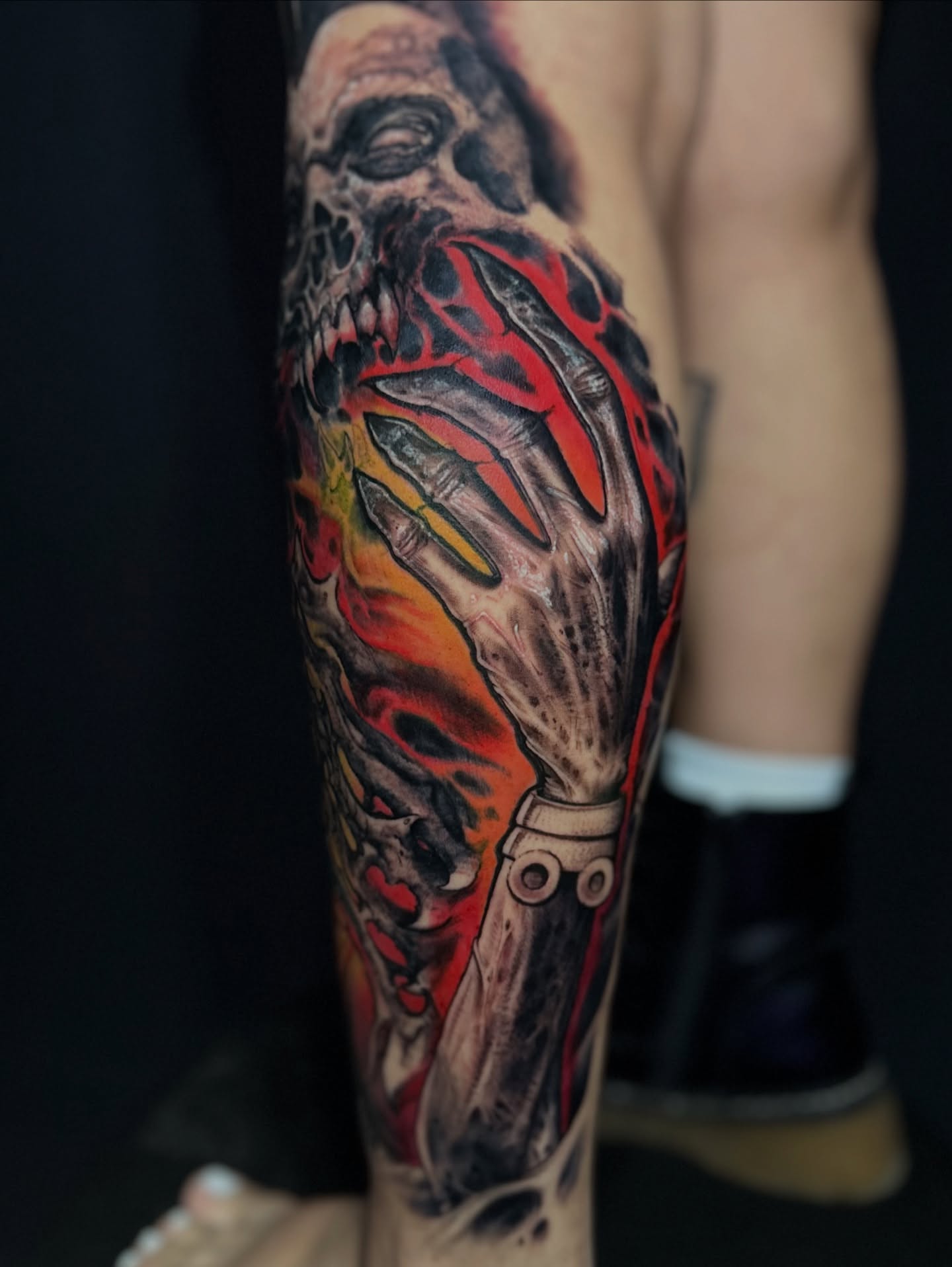 Skull and flame dark realism tattoo on the forearm by Meza Cruz