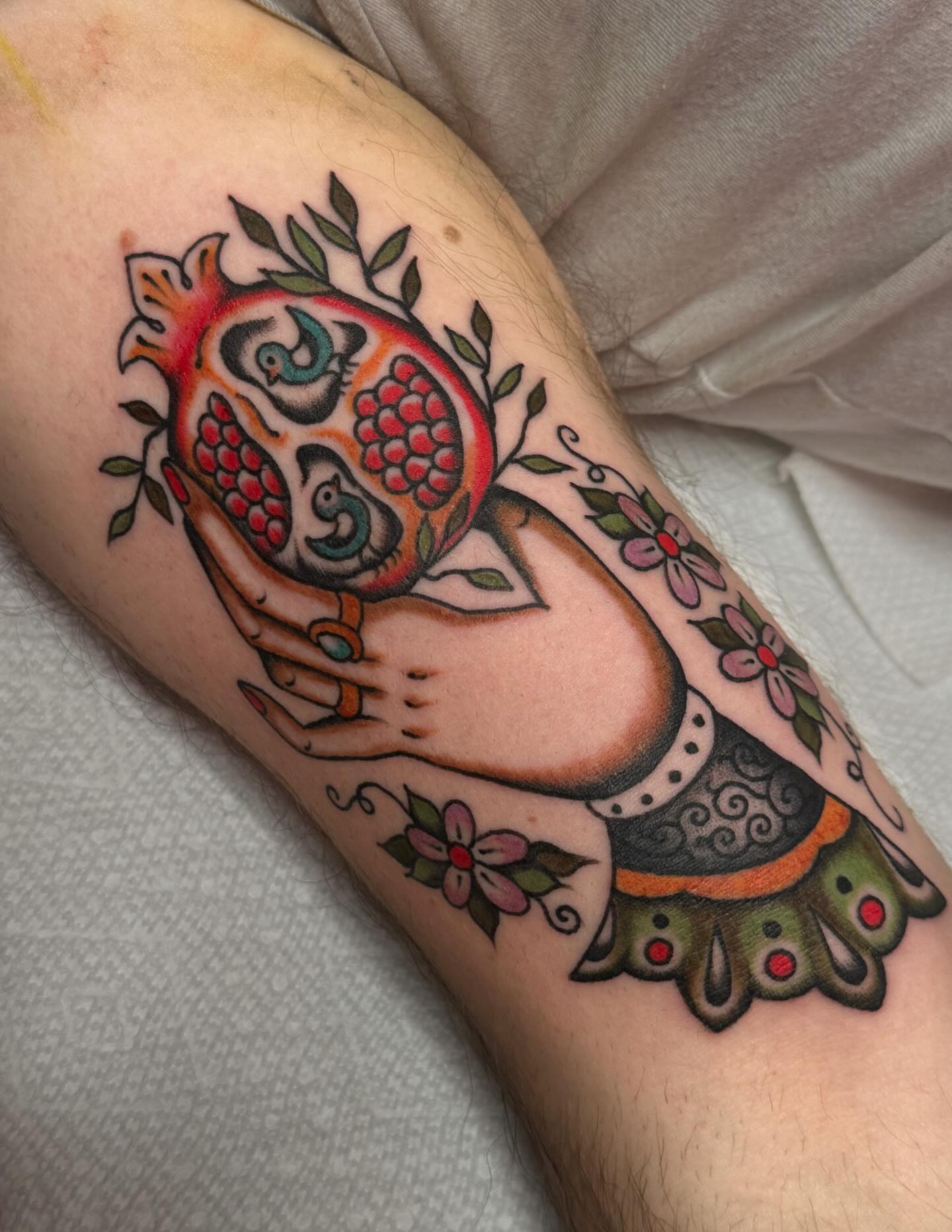 Pomegranate and hand American traditional tattoo on the forearm by B