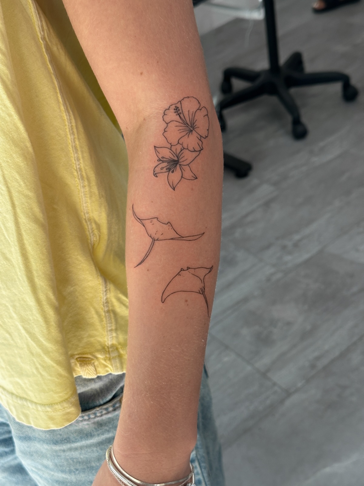 Hibiscus and ginkgo leaves fine line tattoo on the forearm by Alex