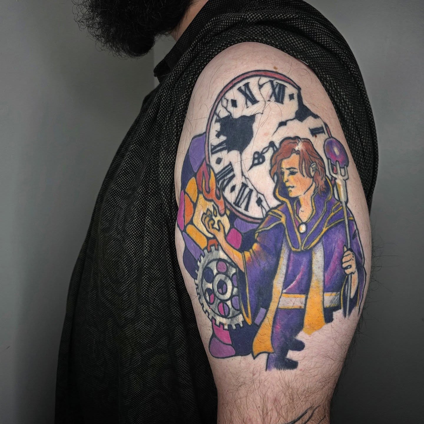 Clock and character illustrative tattoo on the upper arm by julian