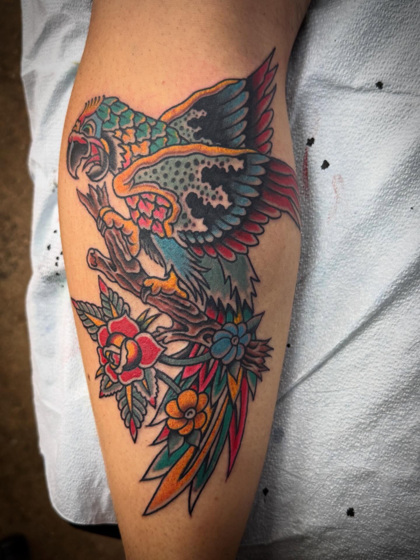 Parrot and floral American traditional tattoo on the forearm by Austin Liebst, Wichita, Kansas