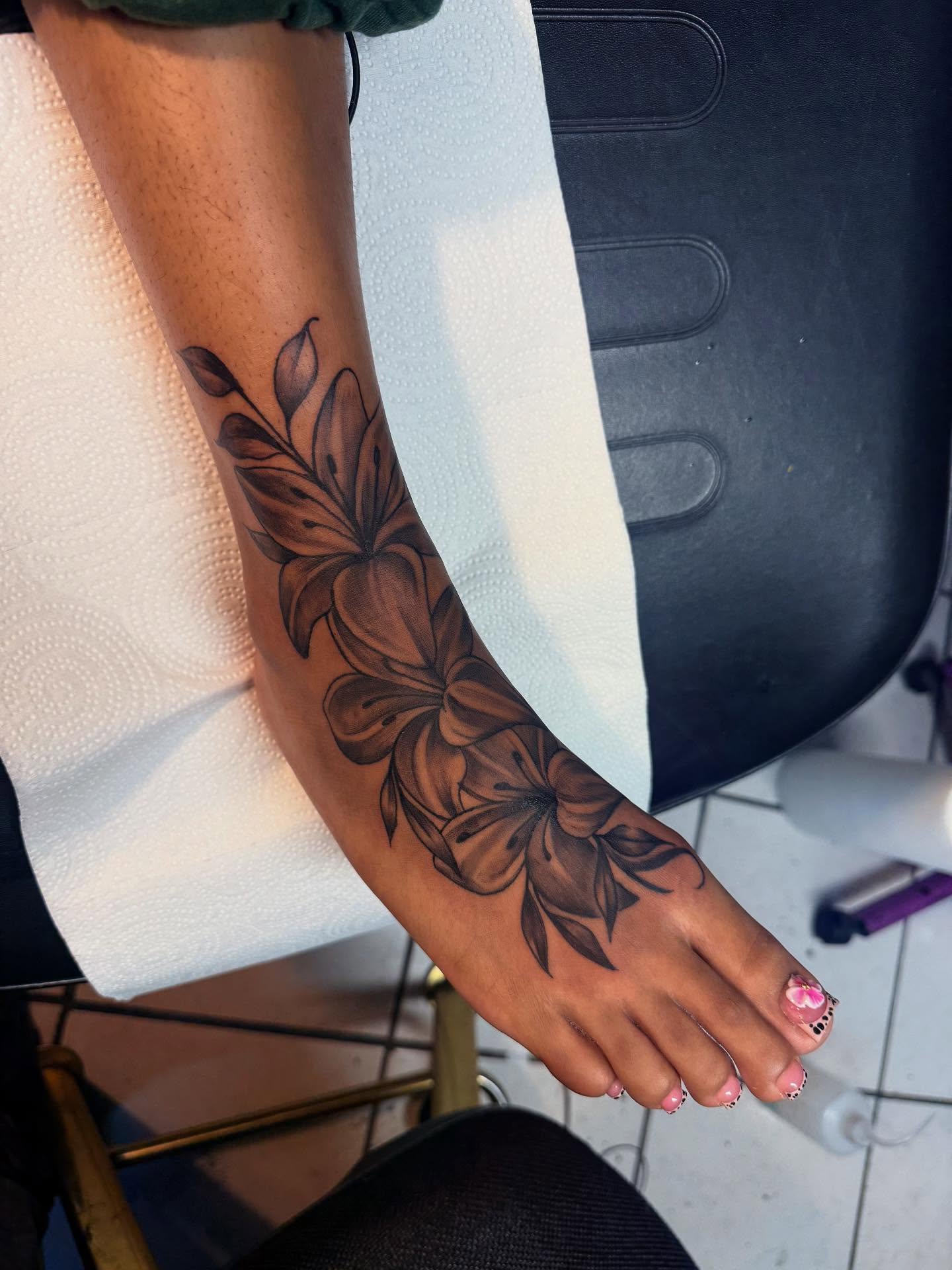 Floral design black and grey tattoo on the foot by GrindHard Quen