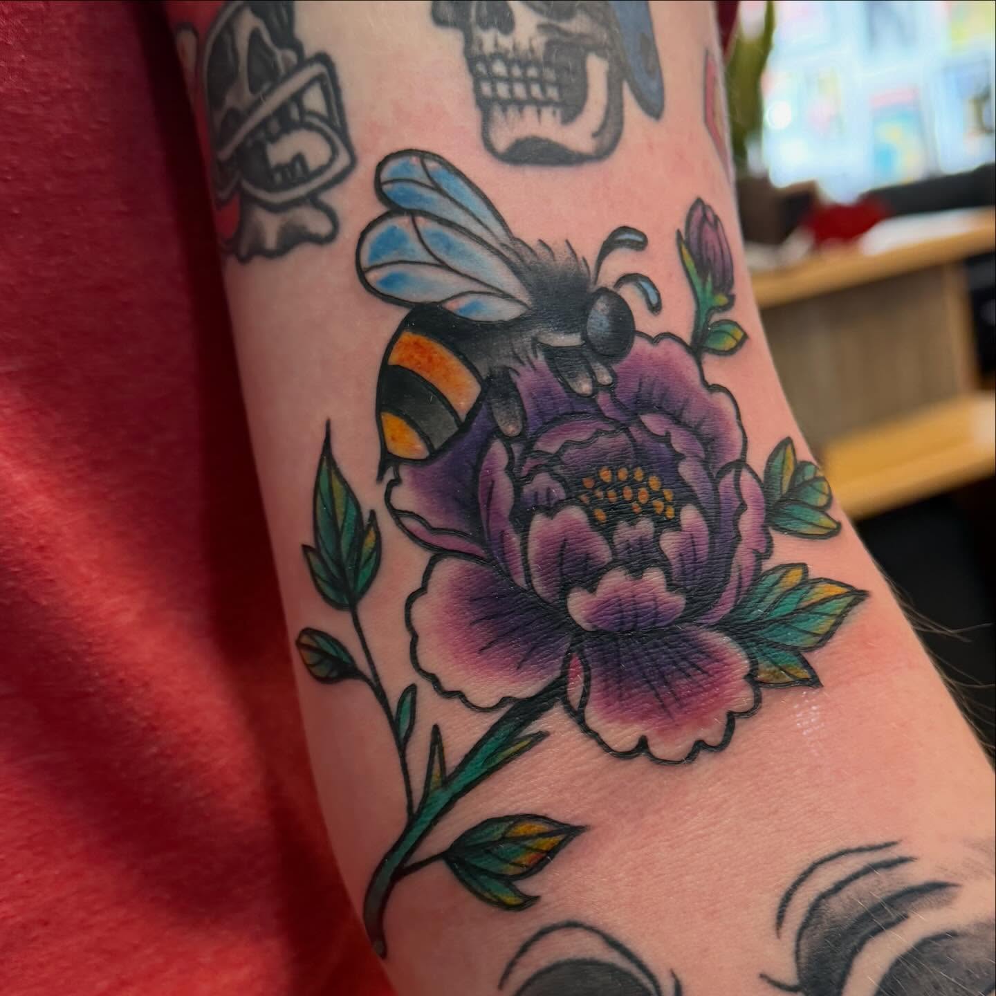 Bee and flower American traditional tattoo on the forearm by Madilynn Klassen