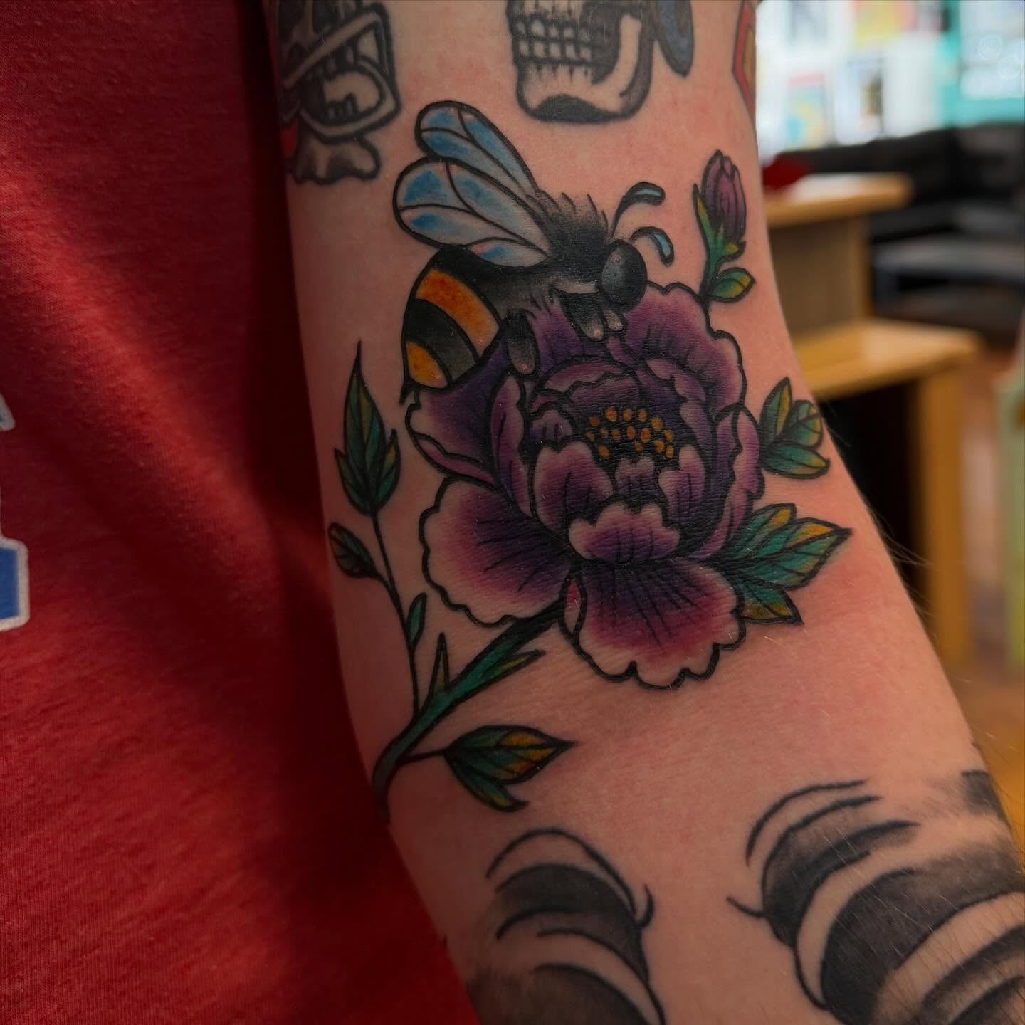 Bee and flower American traditional tattoo on the forearm by Madilynn Klassen
