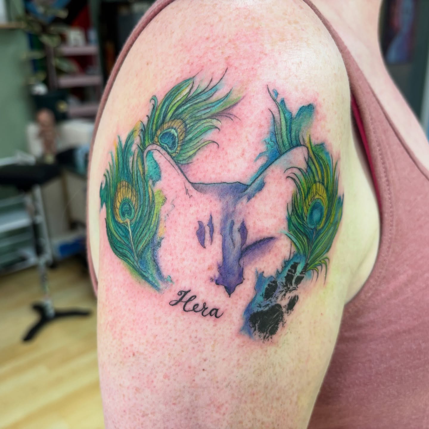 Peacock and paw print watercolor tattoo on the shoulder by Ivanna