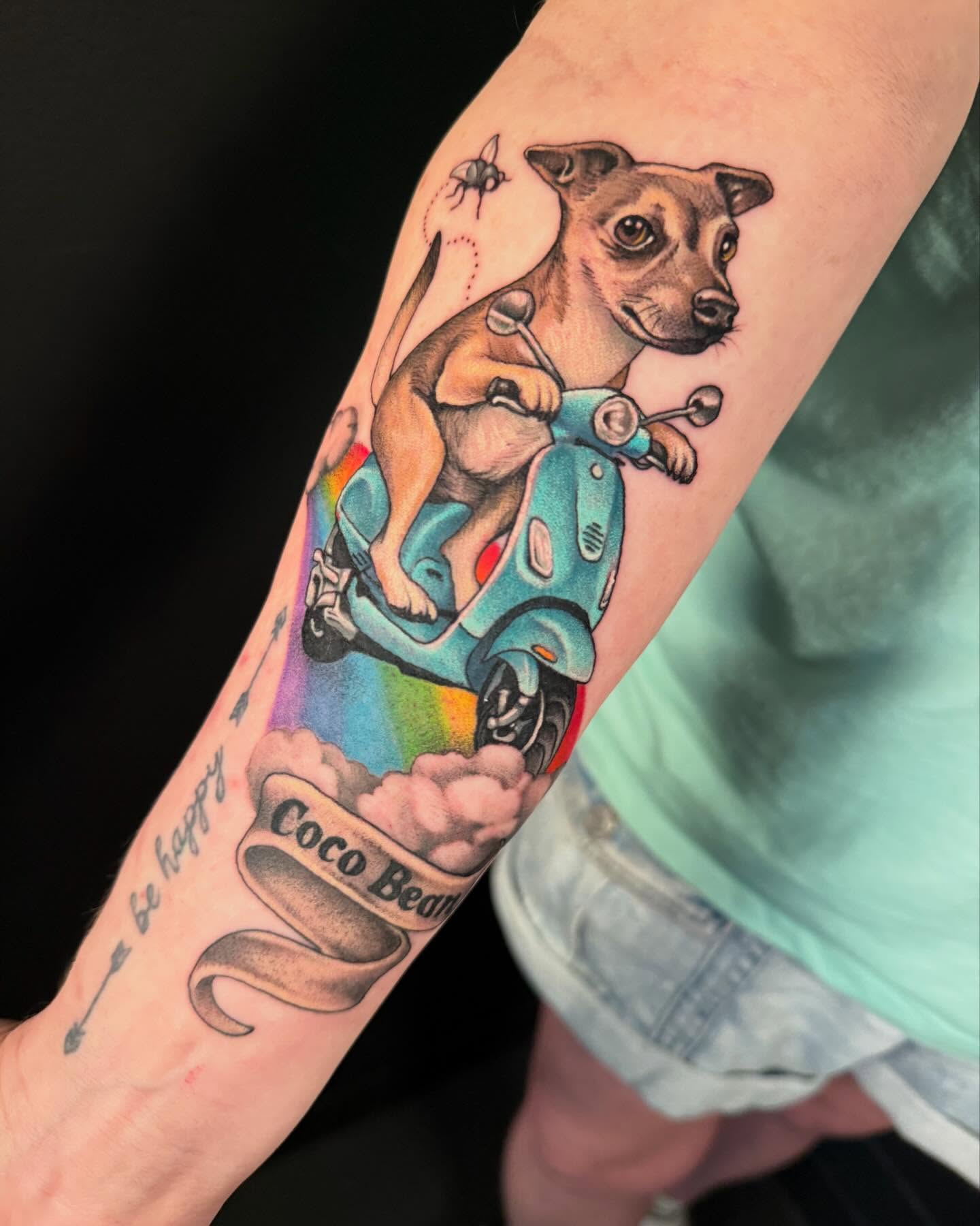 Dog riding scooter American traditional tattoo on the forearm by Jade Lewis