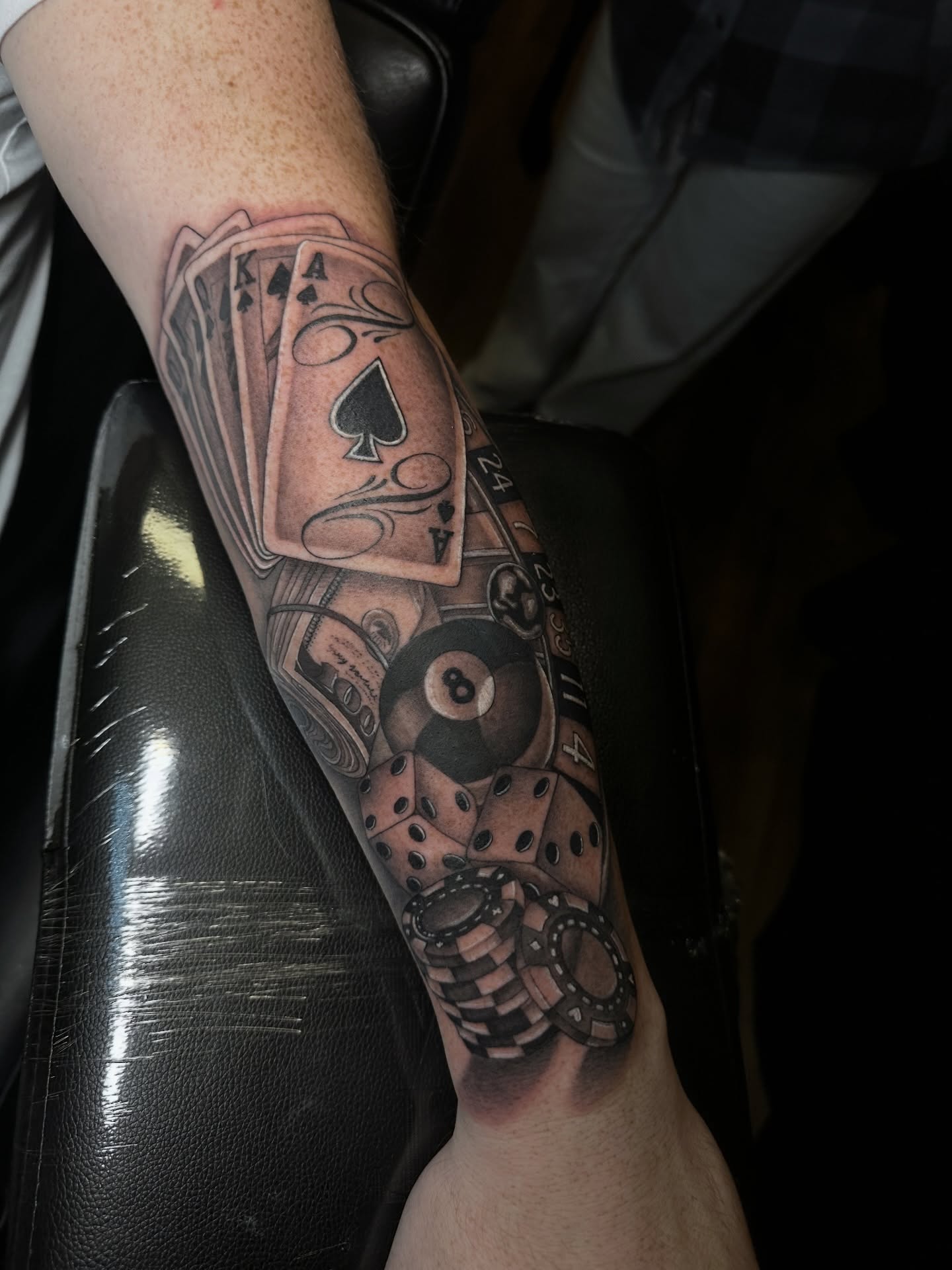 Playing cards and billiard ball realism tattoo on the forearm by Priscilla Michels