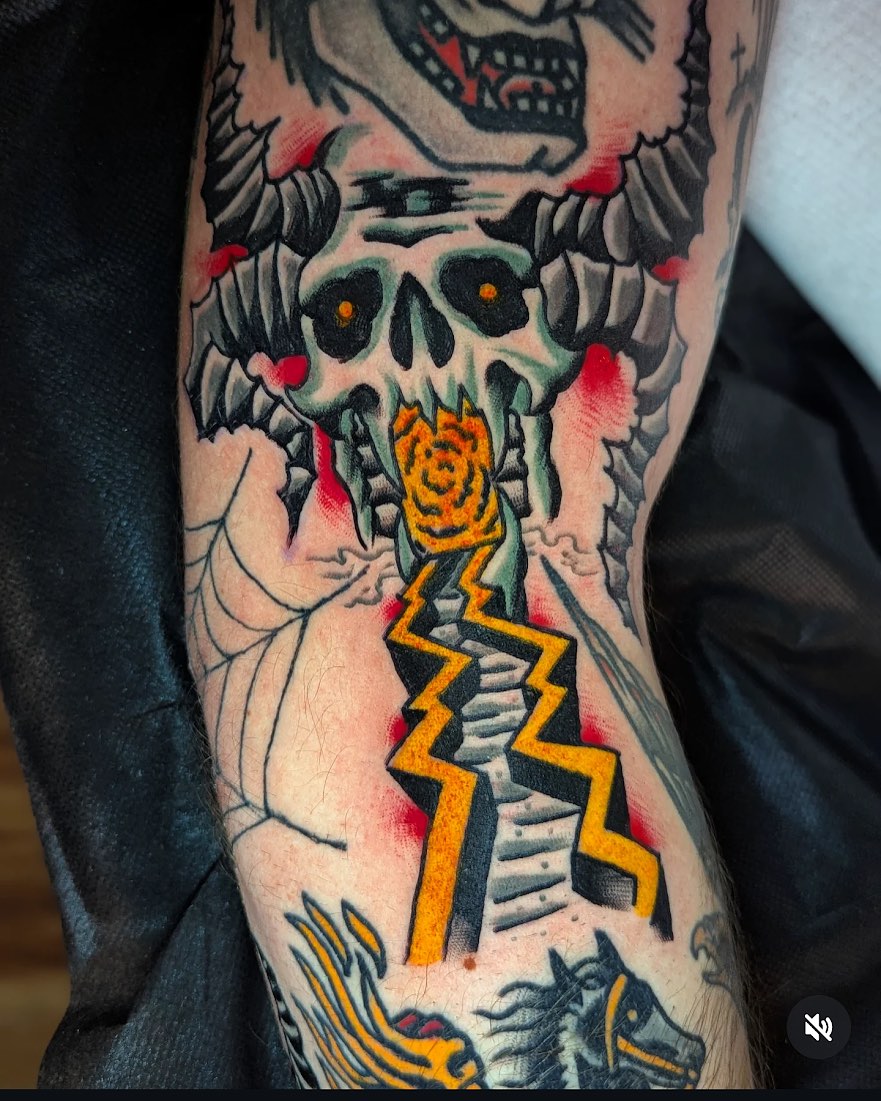 Skull and lightning bolt American traditional tattoo on the forearm by Eric Ward