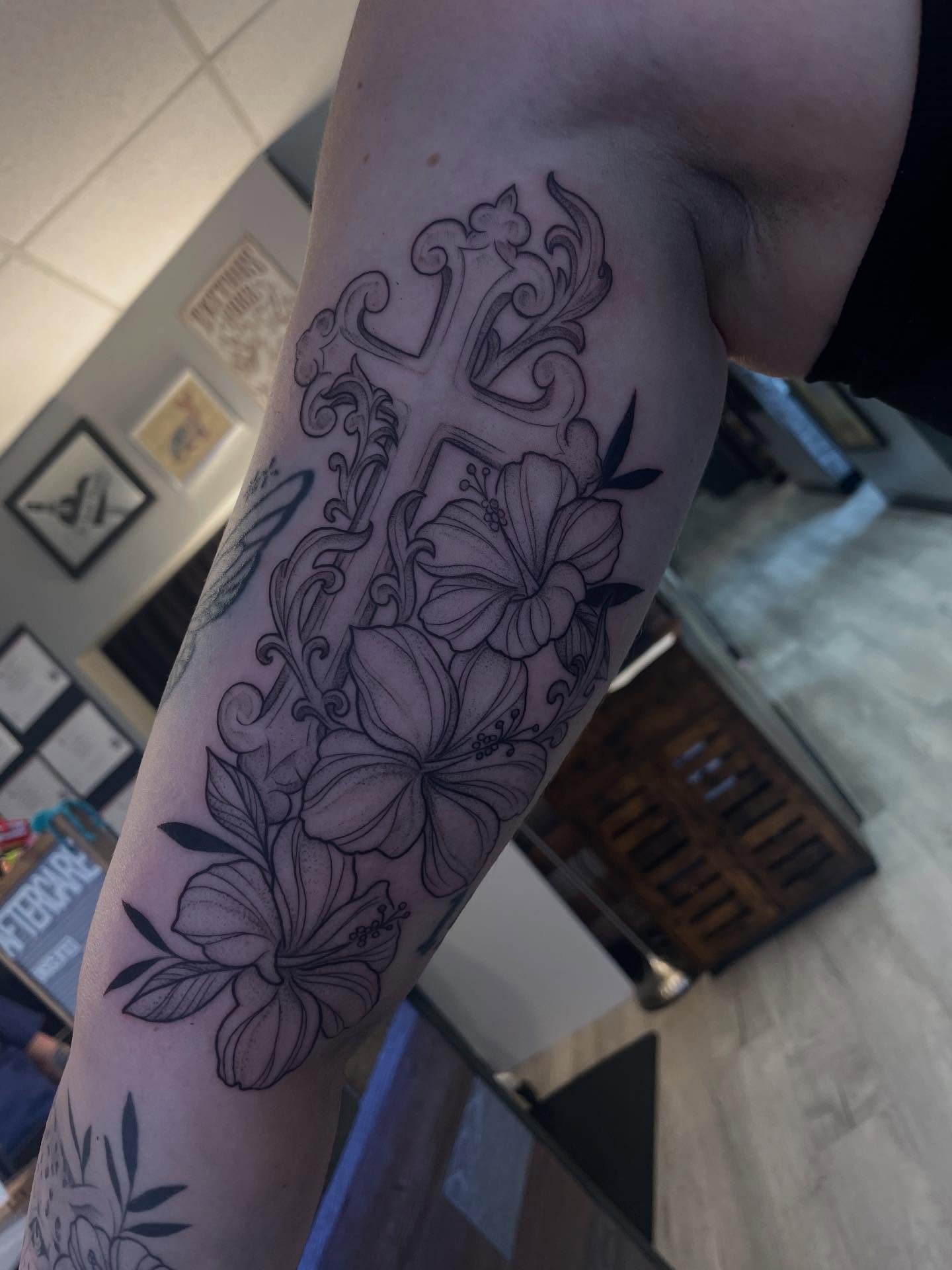 Cross with flowers black and grey tattoo on the forearm by Stevie Timmreck, Utica, Michigan