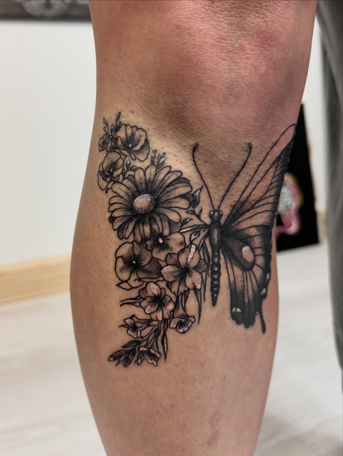 Butterfly and flowers black and grey tattoo on the forearm by Gigi