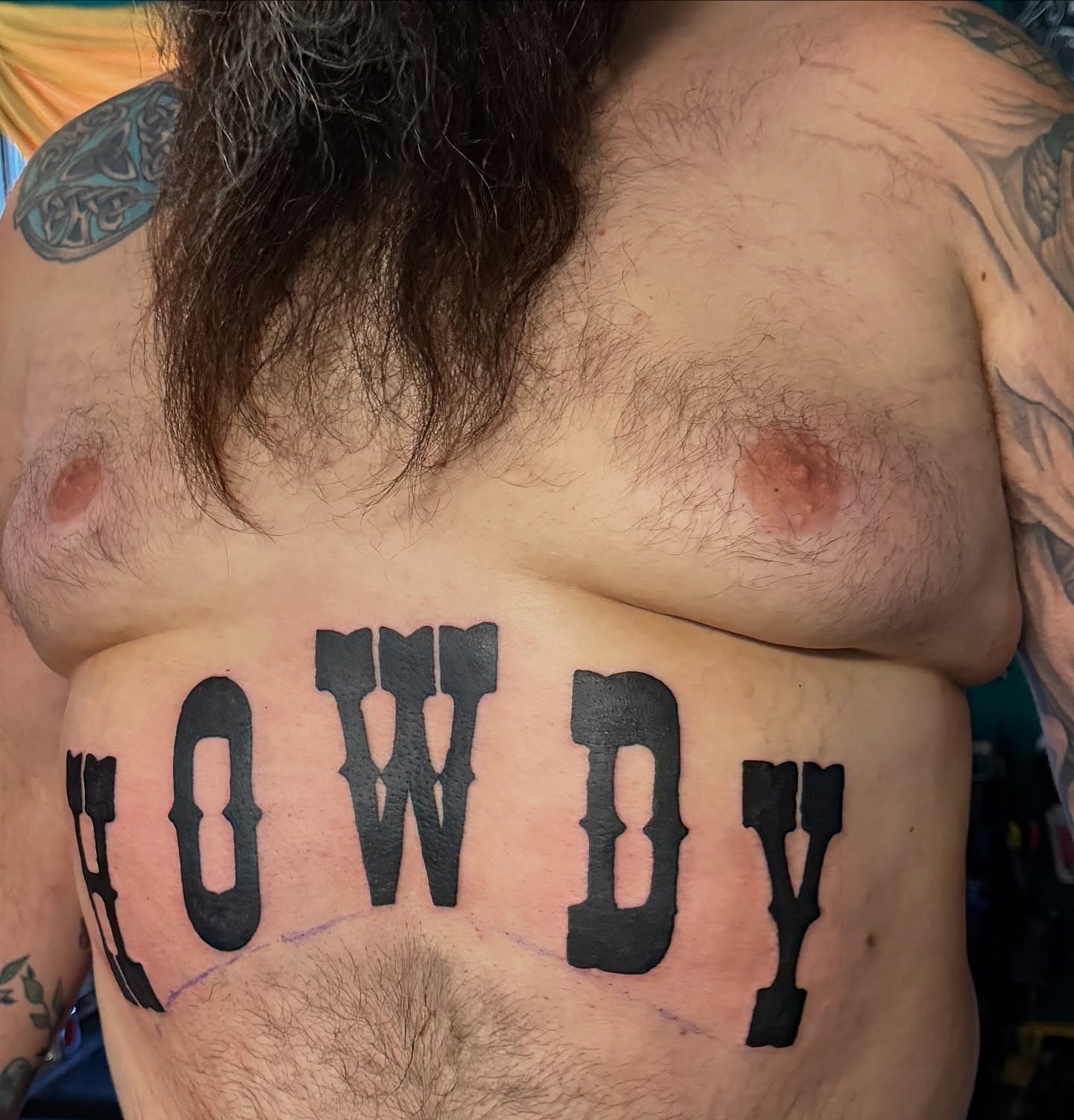 Howdy lettering script tattoo on the chest by Jake Kirk