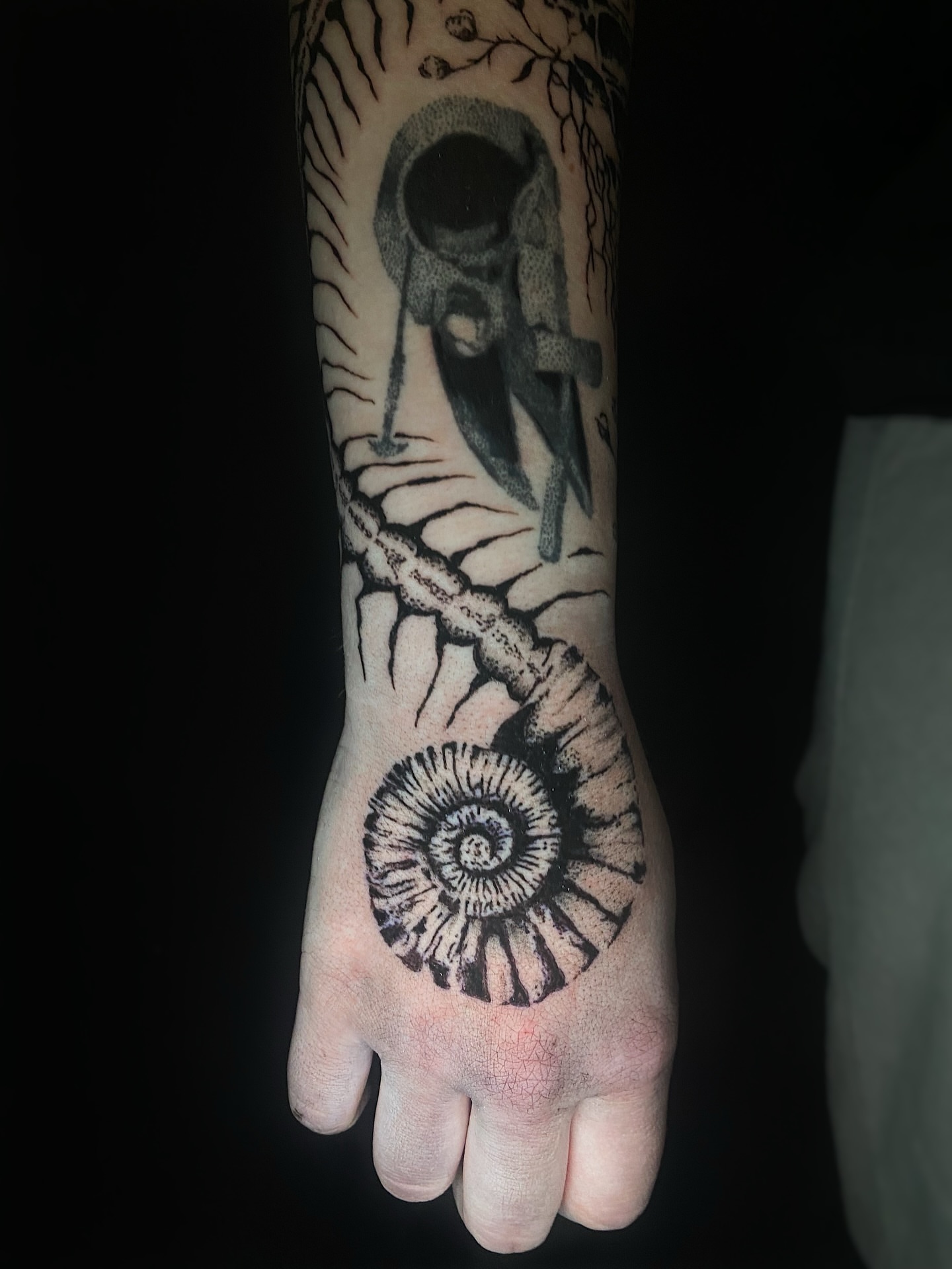 Ammonite fossil black and grey tattoo on the hand by Cherry Jane 🍒