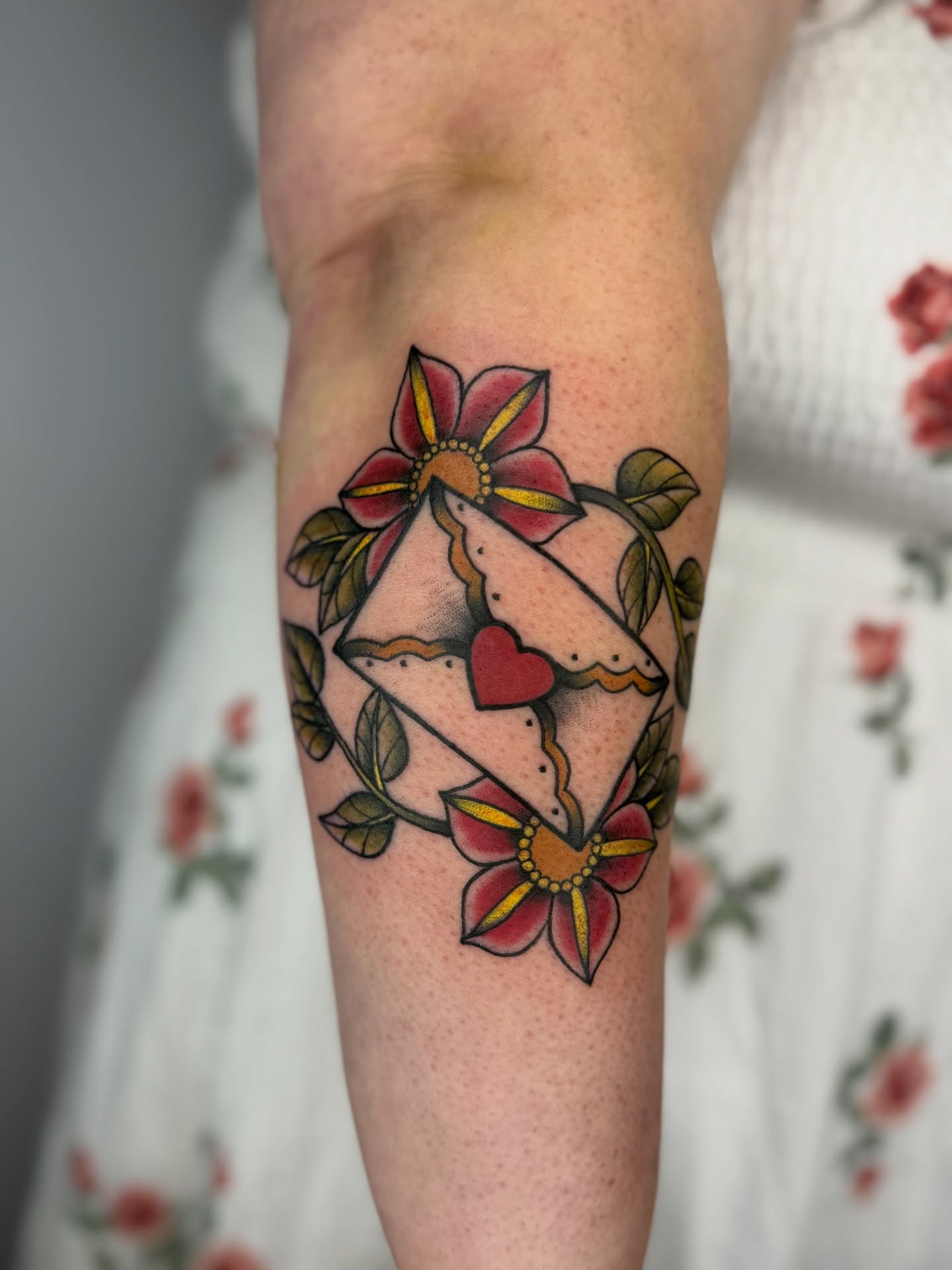 Flower and envelope American traditional tattoo on the forearm by Brandie