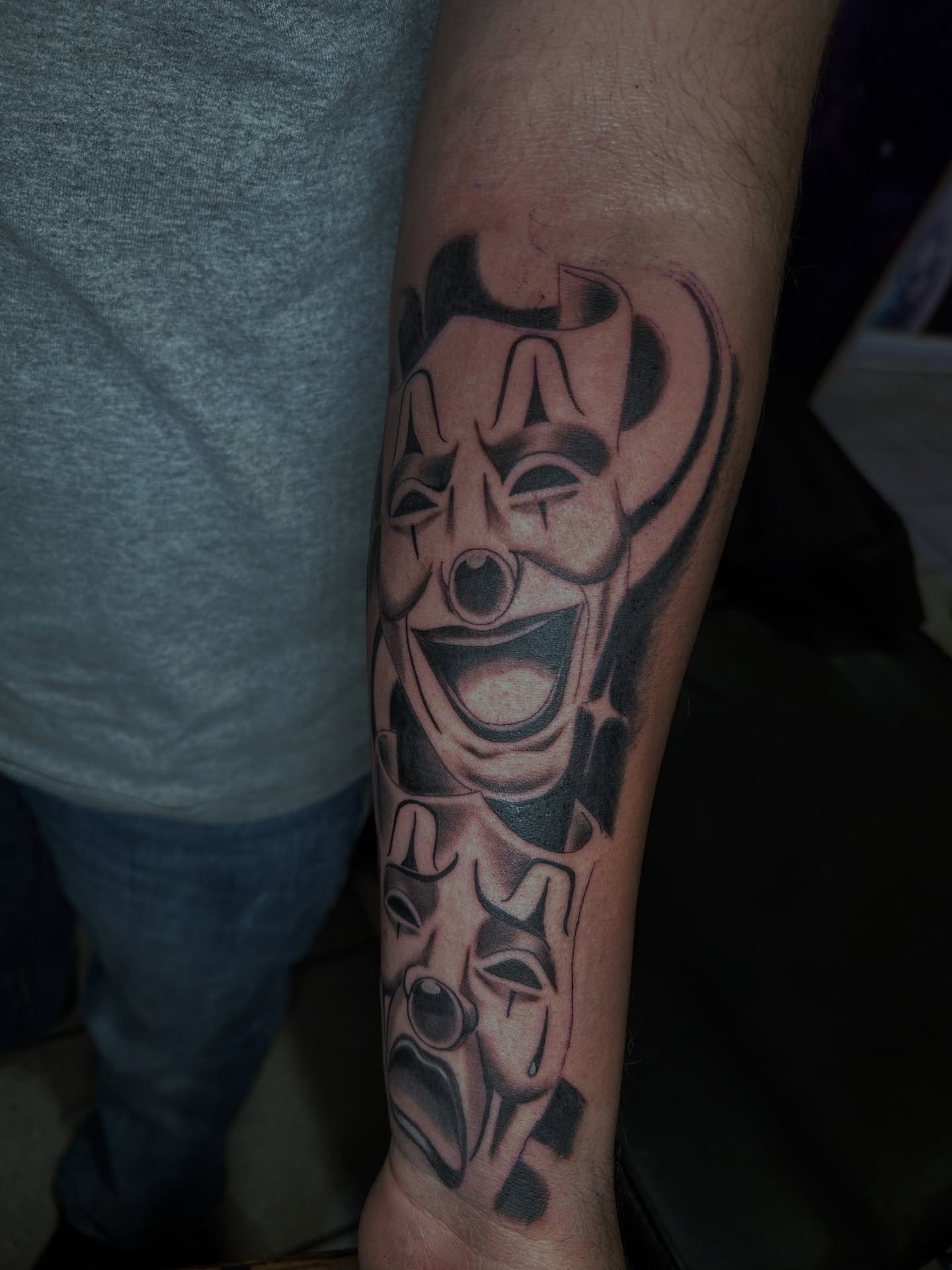 Clown face black and grey tattoo on the forearm by Tito Cross ❤️‍🔥