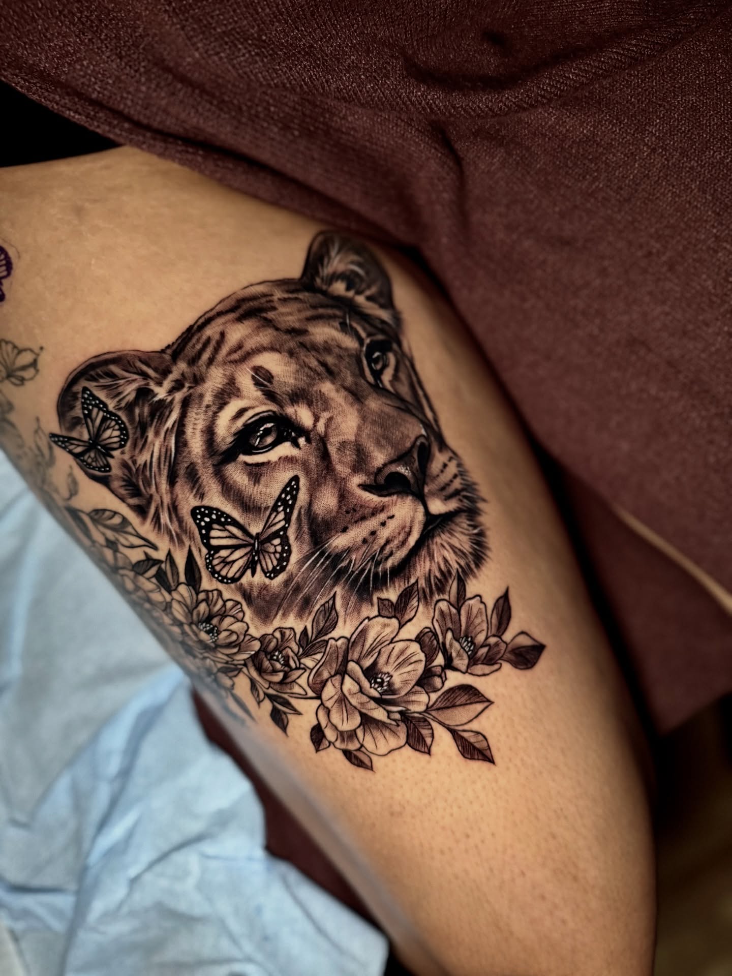 Tiger with butterflies and flowers realism tattoo on the thigh by Montreal Tattoo Artist