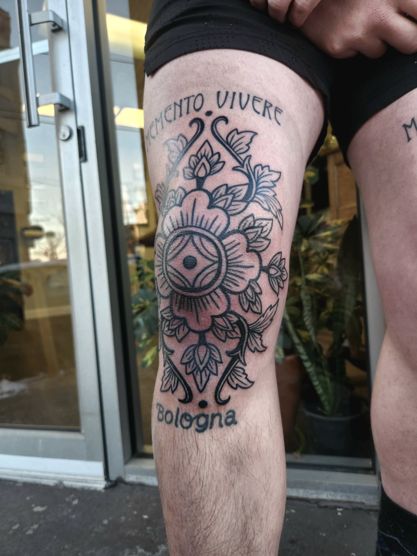Flower and eye black and grey tattoo on the thigh by Ravi Chandra, Mount Shasta, California