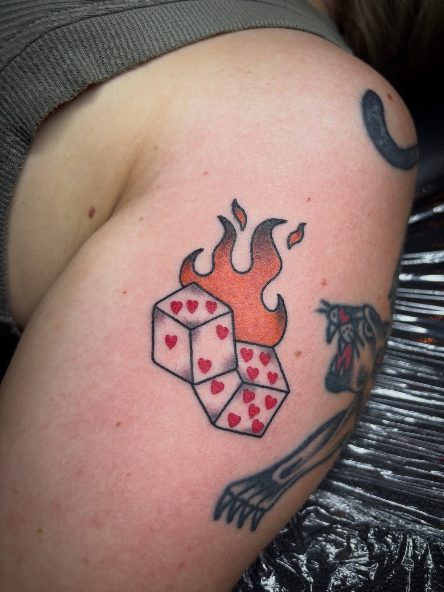 Flaming dice American traditional tattoo on the shoulder by Malia Clark