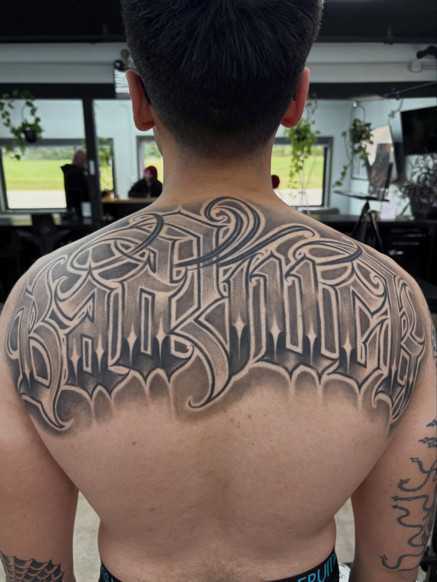 Gothic script lettering script tattoo on the back by Trusty Dizon Tattoo Artist