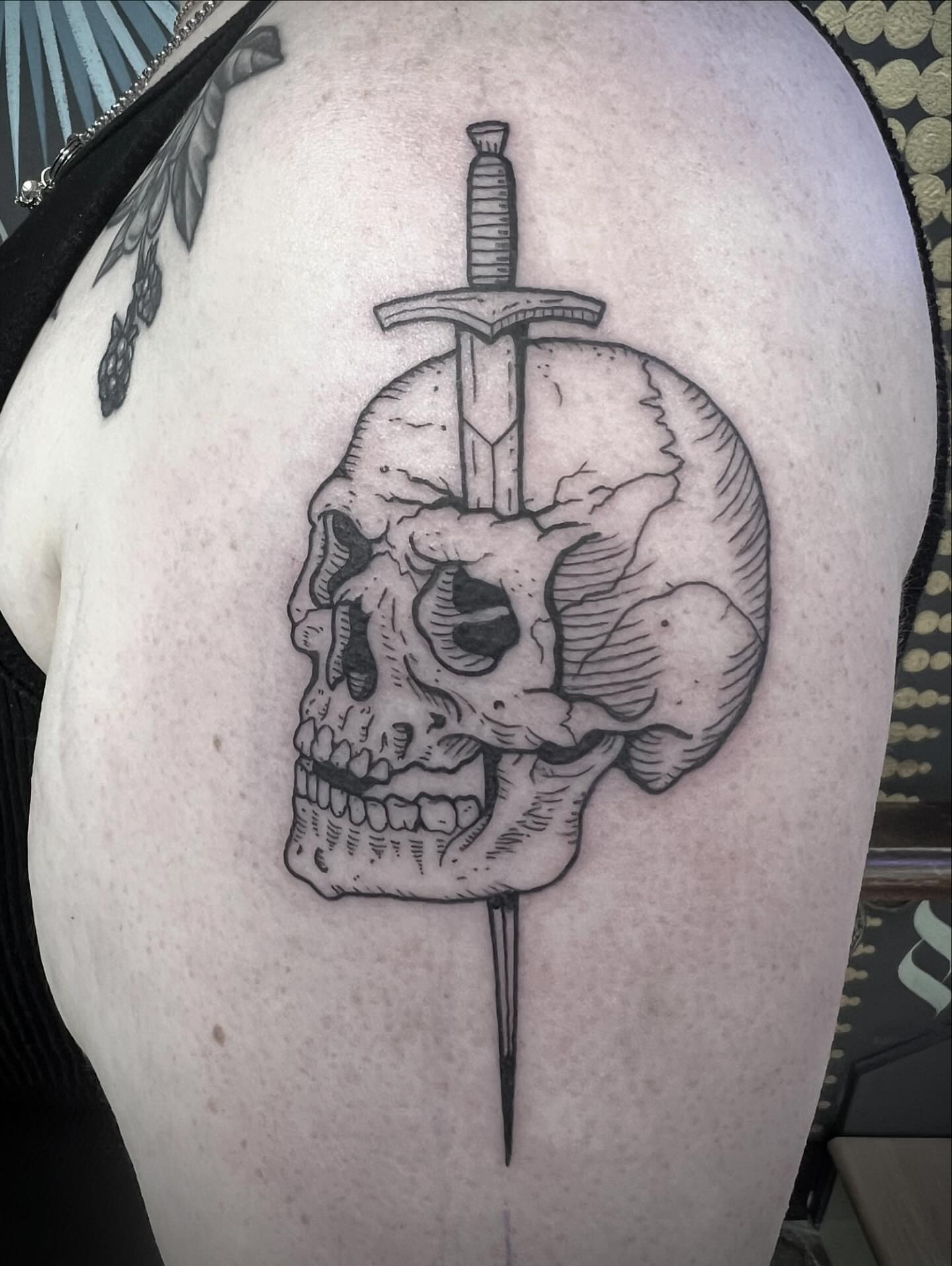 Skull with sword realism tattoo on the shoulder by Natalie Phillips, Oakland, California