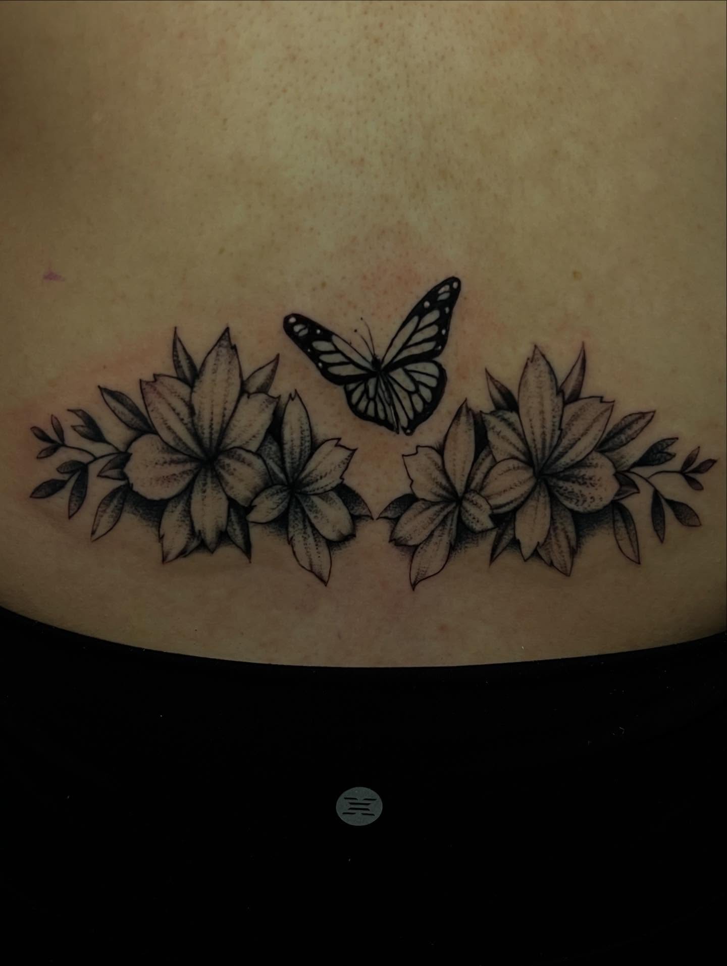 Flowers and butterfly black and grey tattoo on the torso by Dany