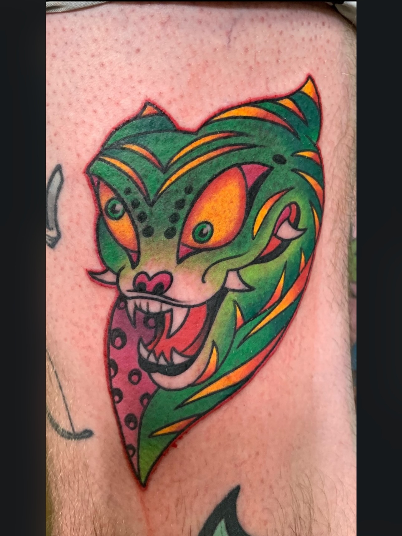 Joker-like face American traditional tattoo on the forearm by Brandon Bracamonte