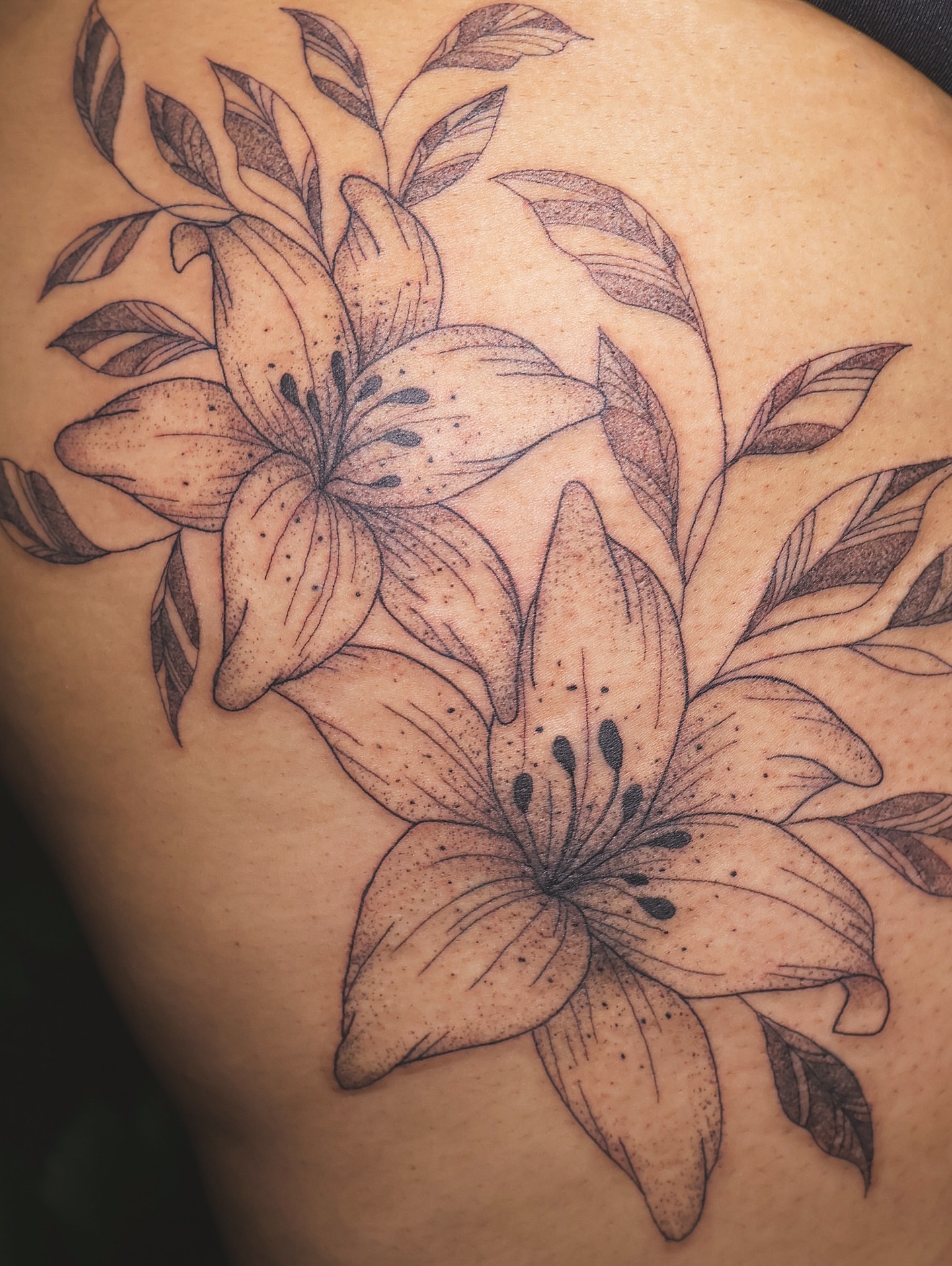 Lilies black and grey tattoo on the thigh by 𝑭𝒊𝒏𝒆 𝑳𝒊𝒏𝒆 𝑻𝒂𝒕𝒕𝒐𝒐’𝒔