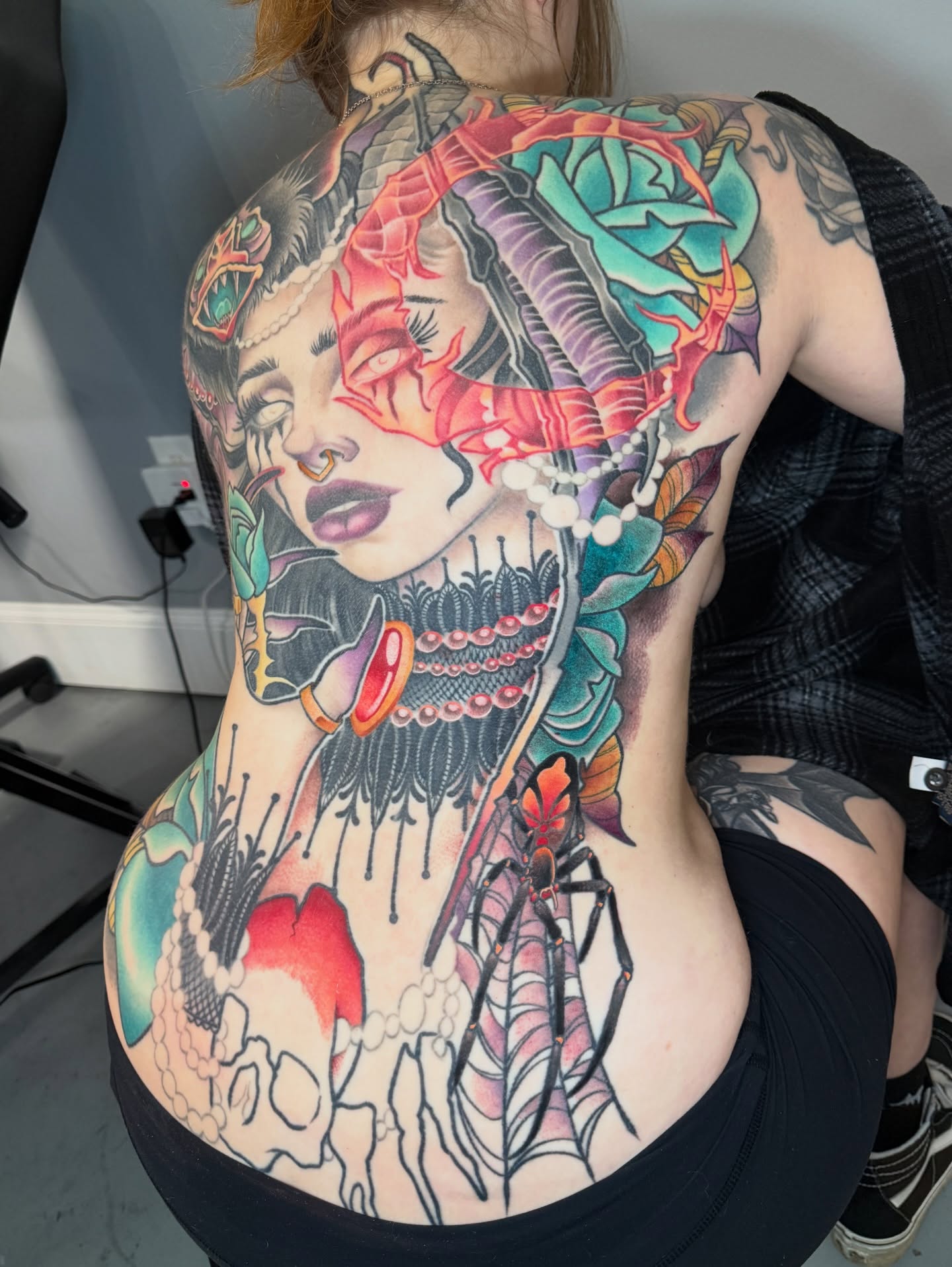 Woman with dragon American traditional tattoo on the back by Sam Castro