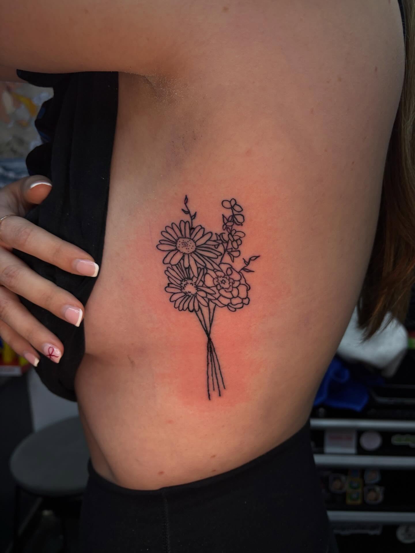 Flower bouquet fine line tattoo on the ribs by Jenna Clayton