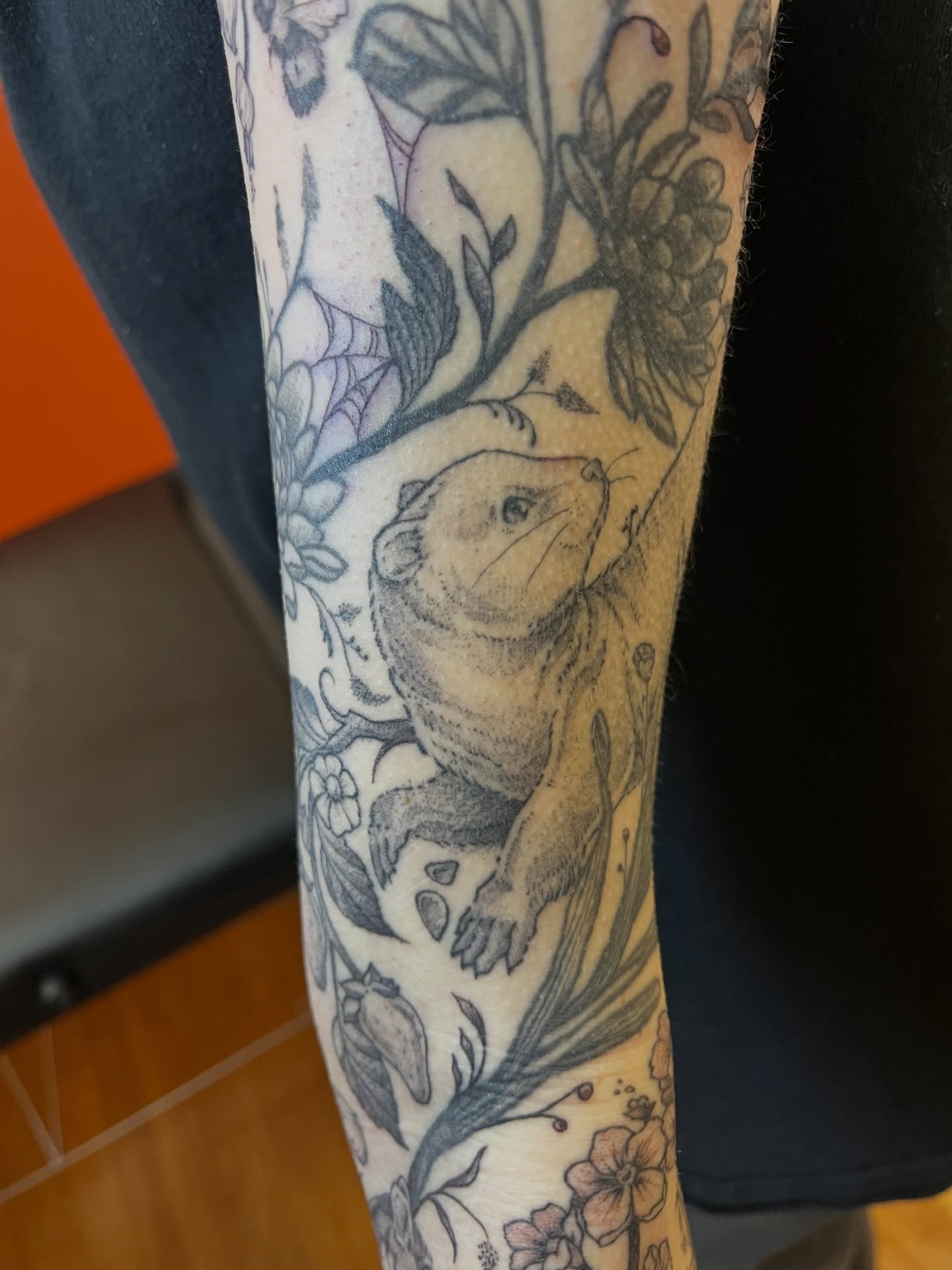 Groundhog and floral black and grey tattoo on the forearm by Gianna Calisi