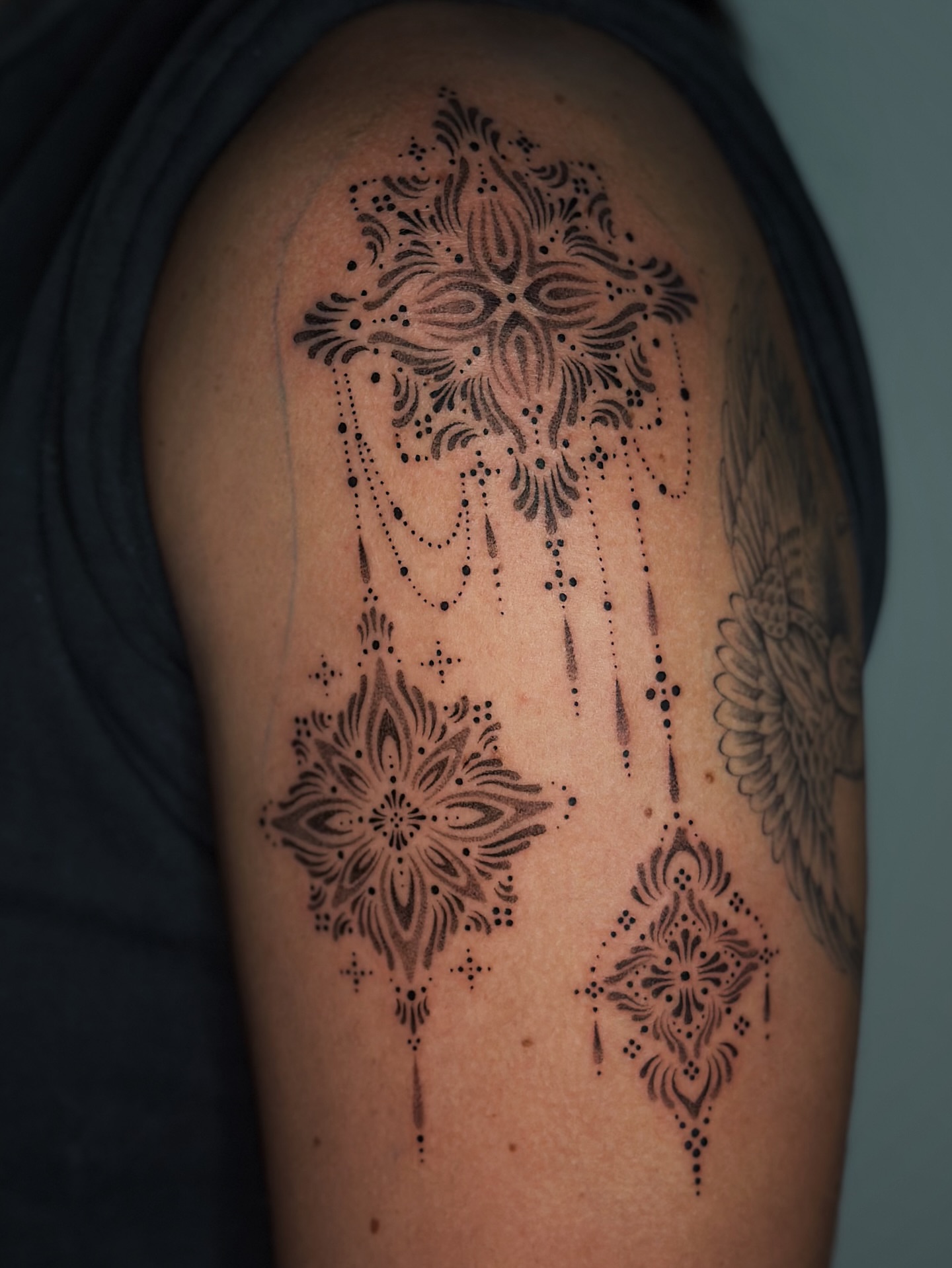 Cross and floral dotwork tattoo on the shoulder by Lauryn Jenesis