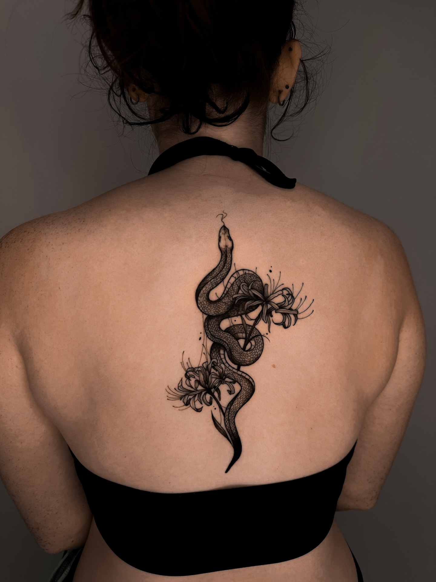 Snake and flowers dotwork tattoo on the back by Lauren