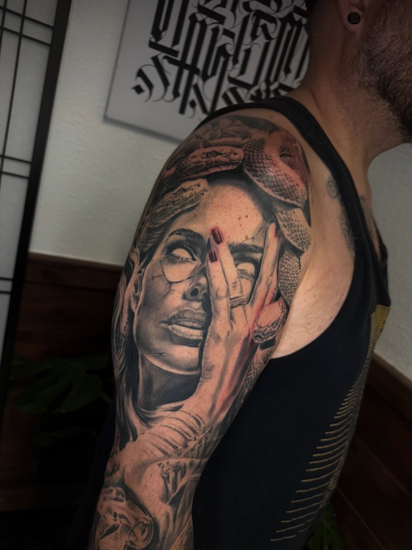 Woman with snake realism tattoo on the upper arm by Sloe Rivera