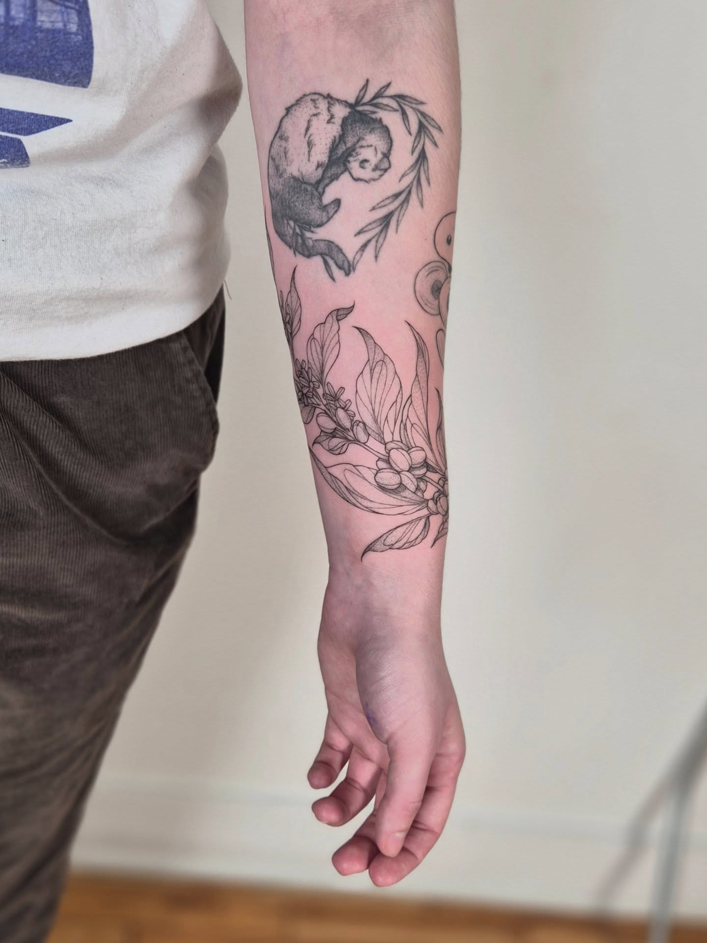 Koala and floral black and grey tattoo on the forearm by Sophorn Long (soapy)