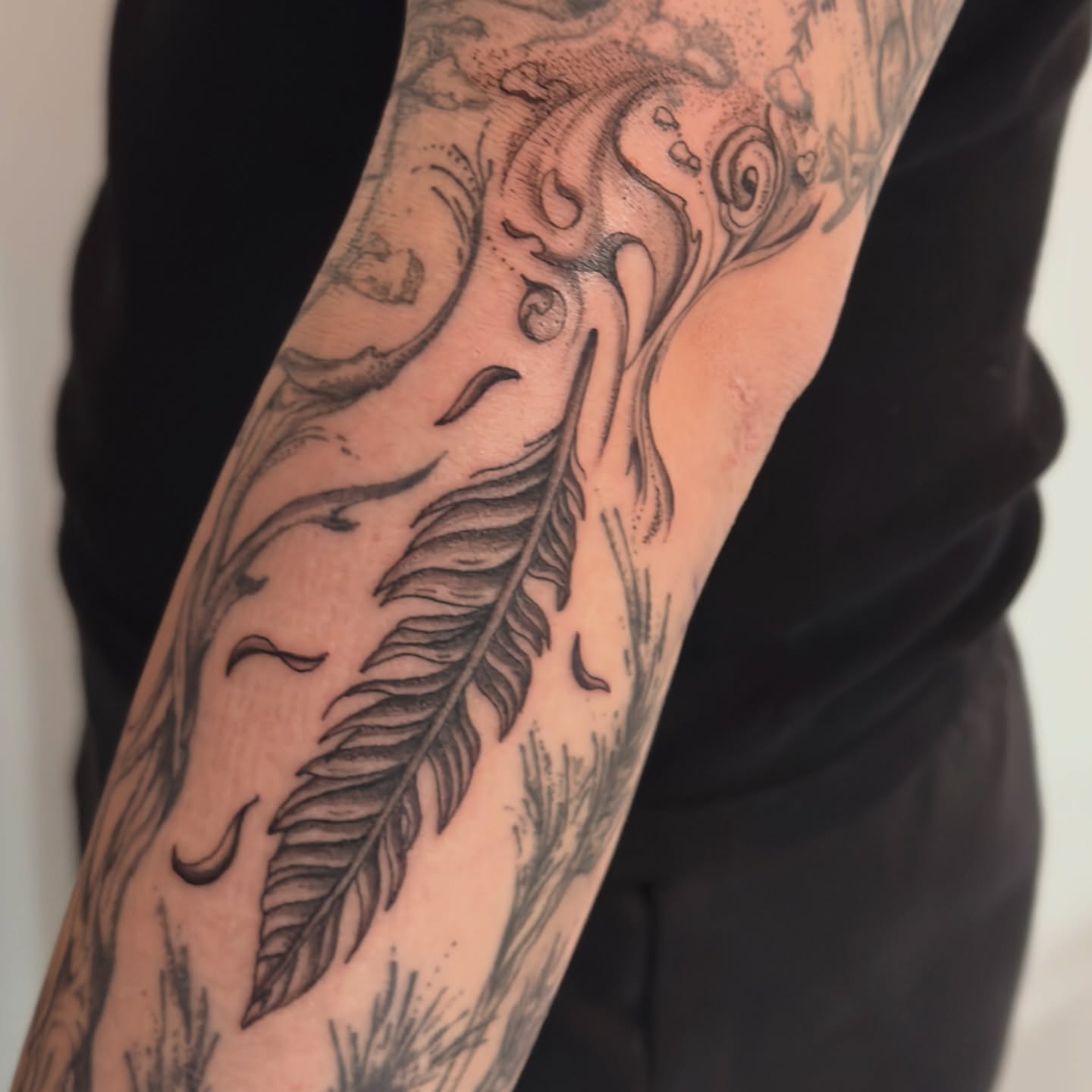 Feather black and grey tattoo on the forearm by jake.inks
