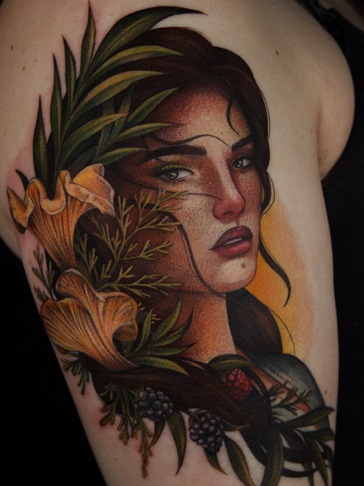Woman with floral elements realism tattoo on the shoulder by caliope yiannos