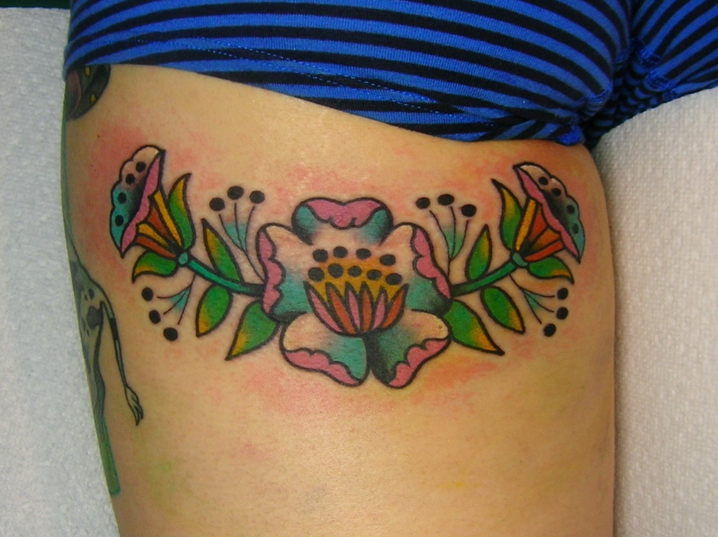 Floral arrangement American traditional tattoo on the thigh by edith🌷, Murfreesboro, Tennessee