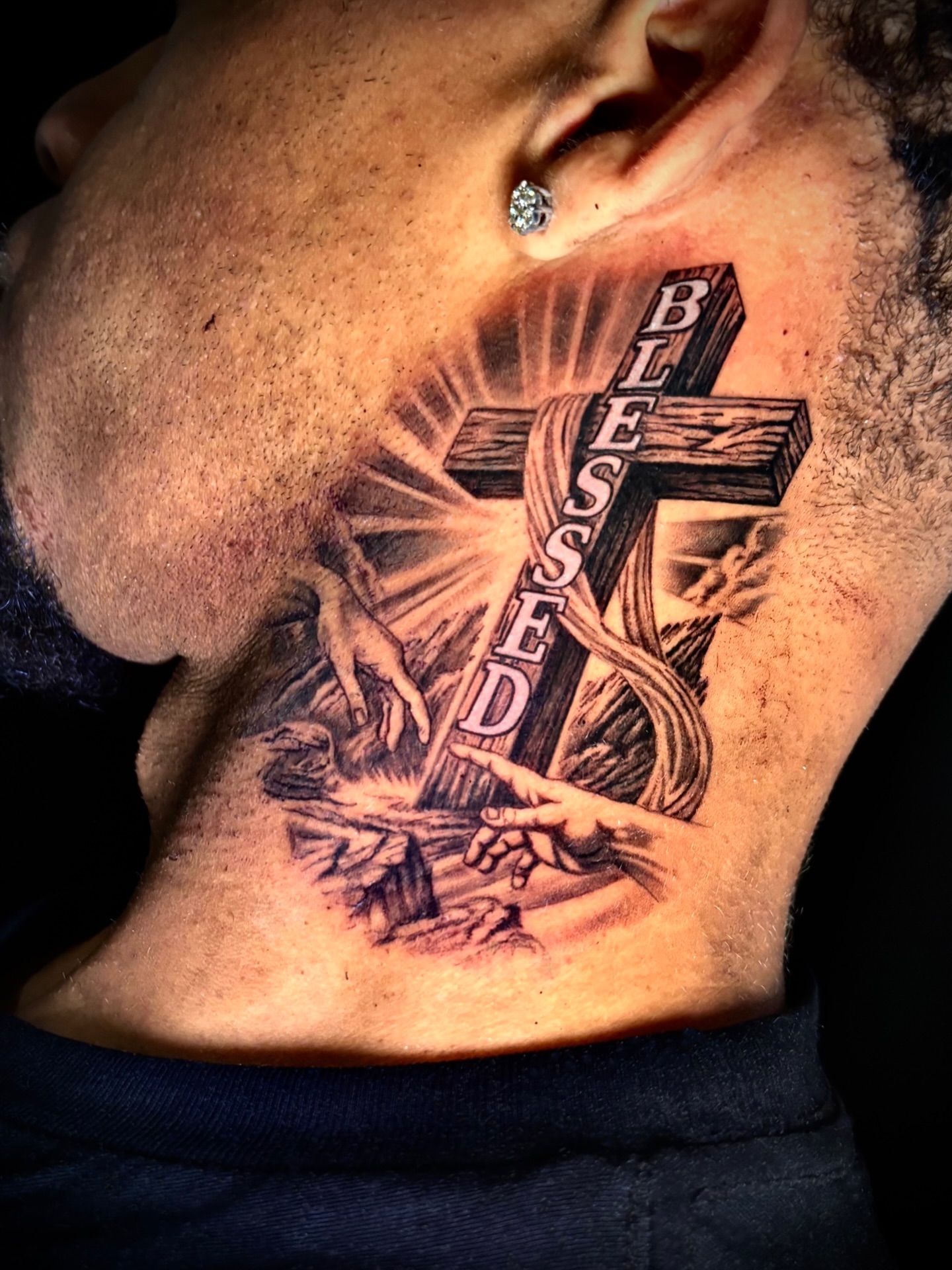 Cross with hands black and grey tattoo on the chest by Tattoos by Marcy