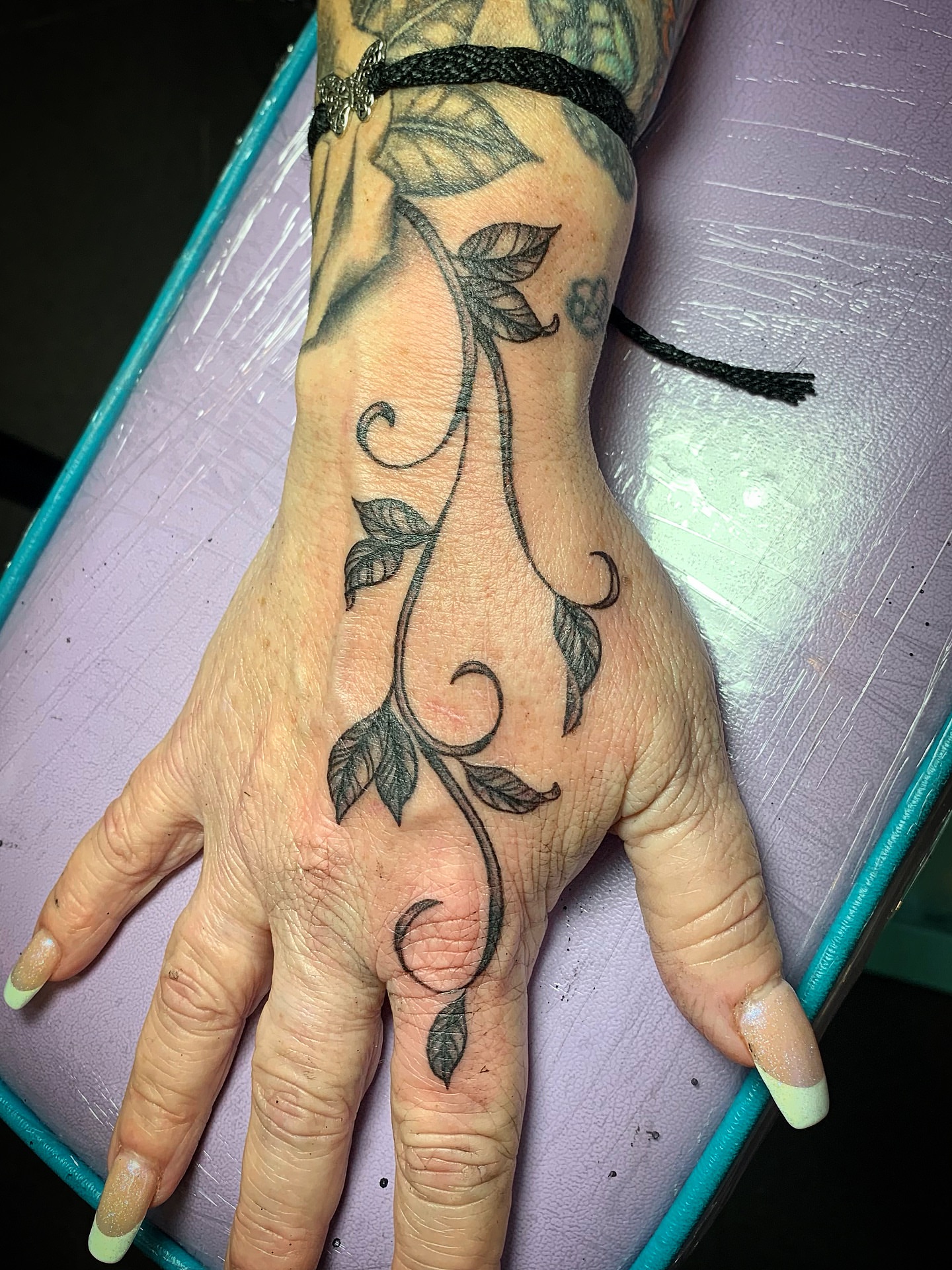 Vines black and grey tattoo on the hand by Laura