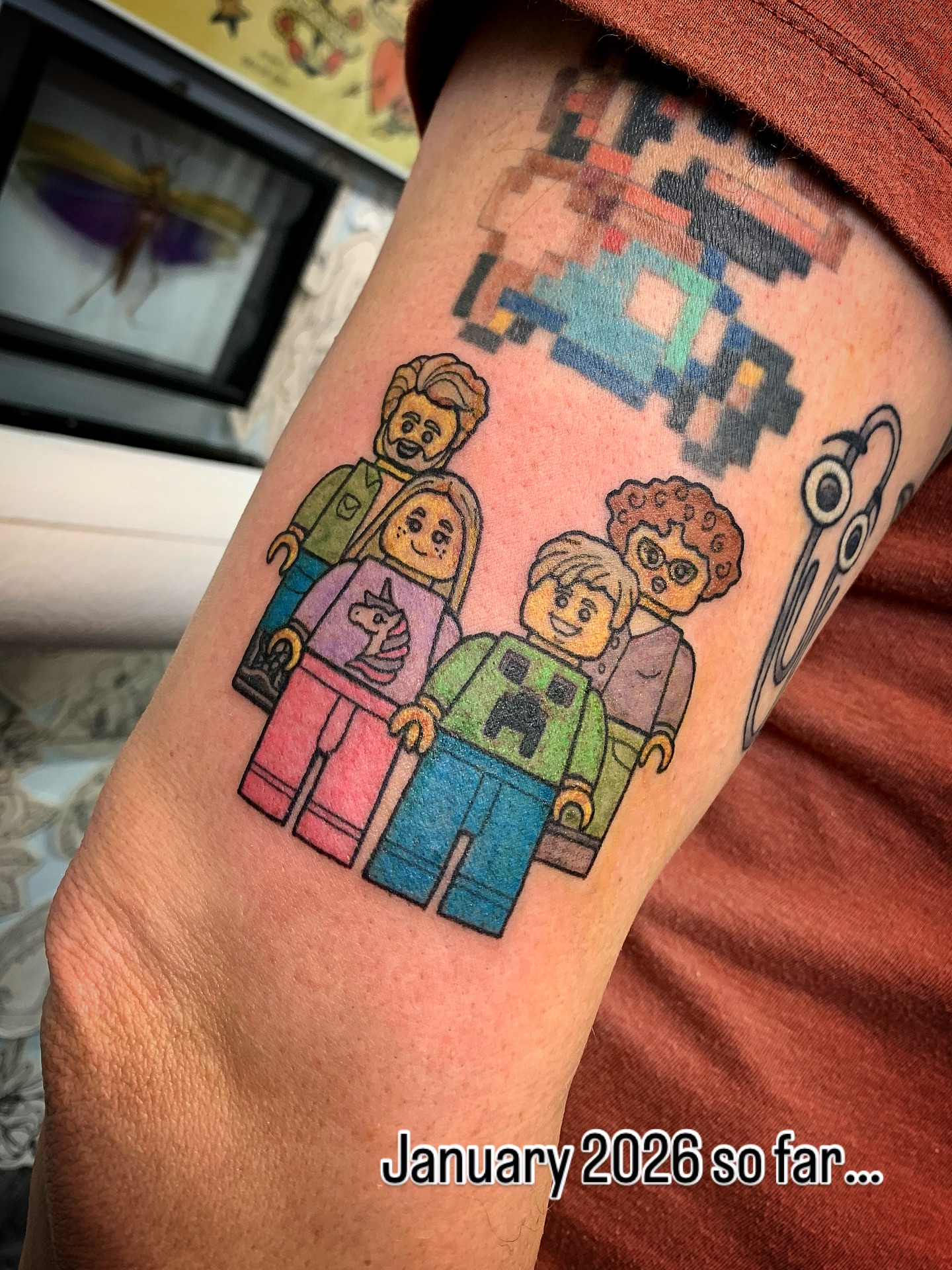 LEGO family illustrative tattoo on the forearm by Laura