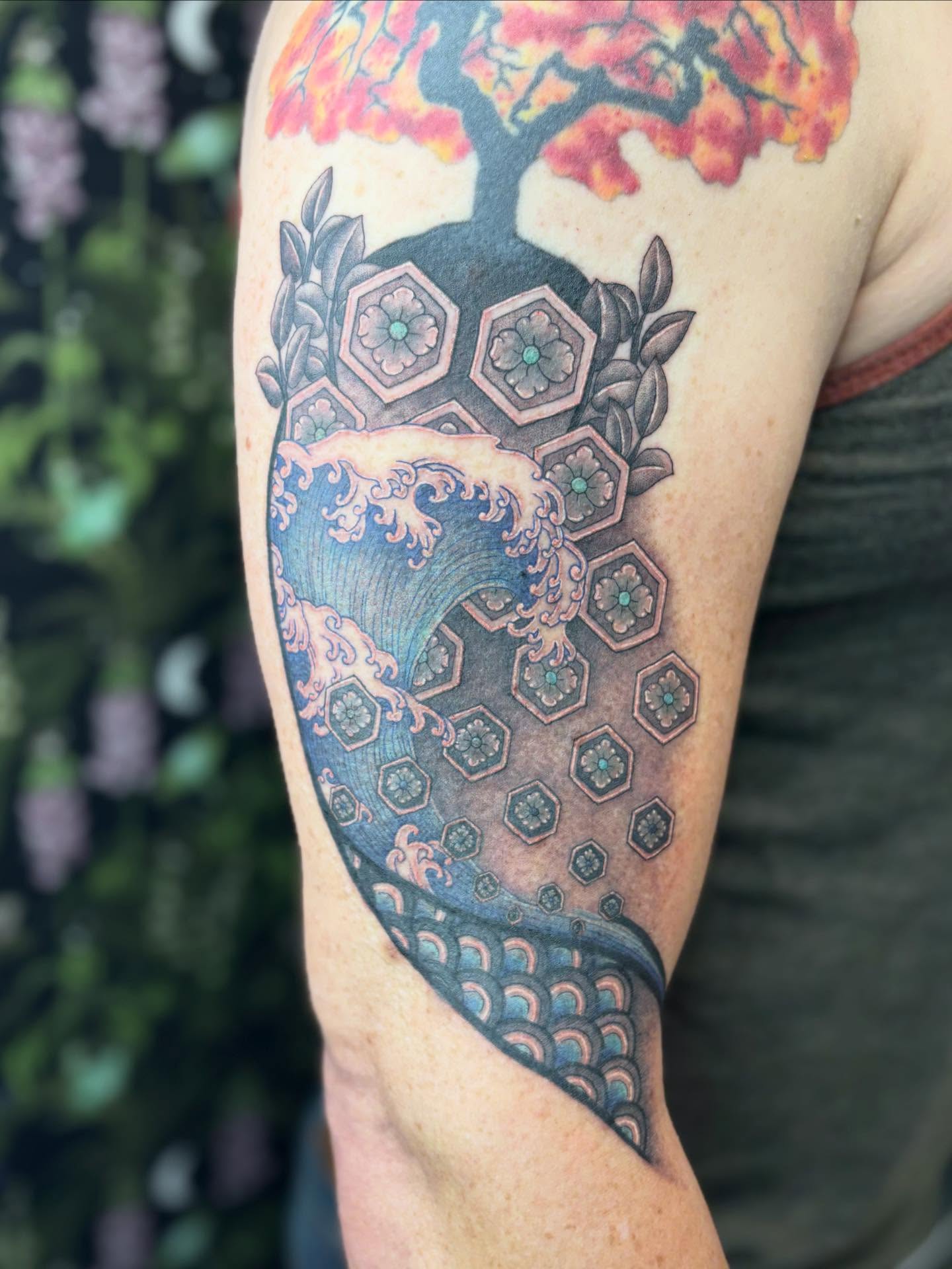 Wave and tree geometric tattoo on the upper arm by Olivia Buch