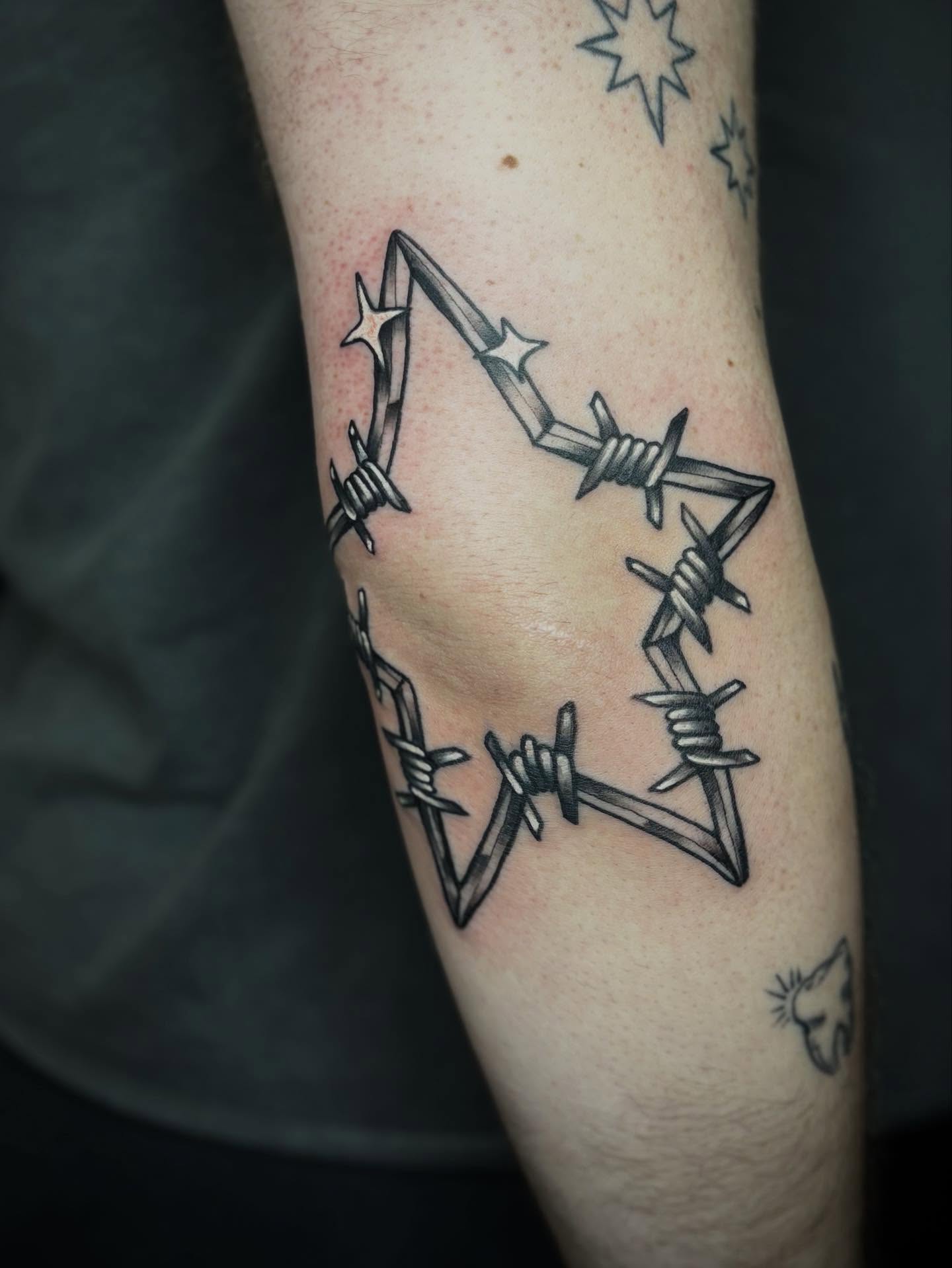 Barbed wire star black and grey tattoo on the forearm by Mim